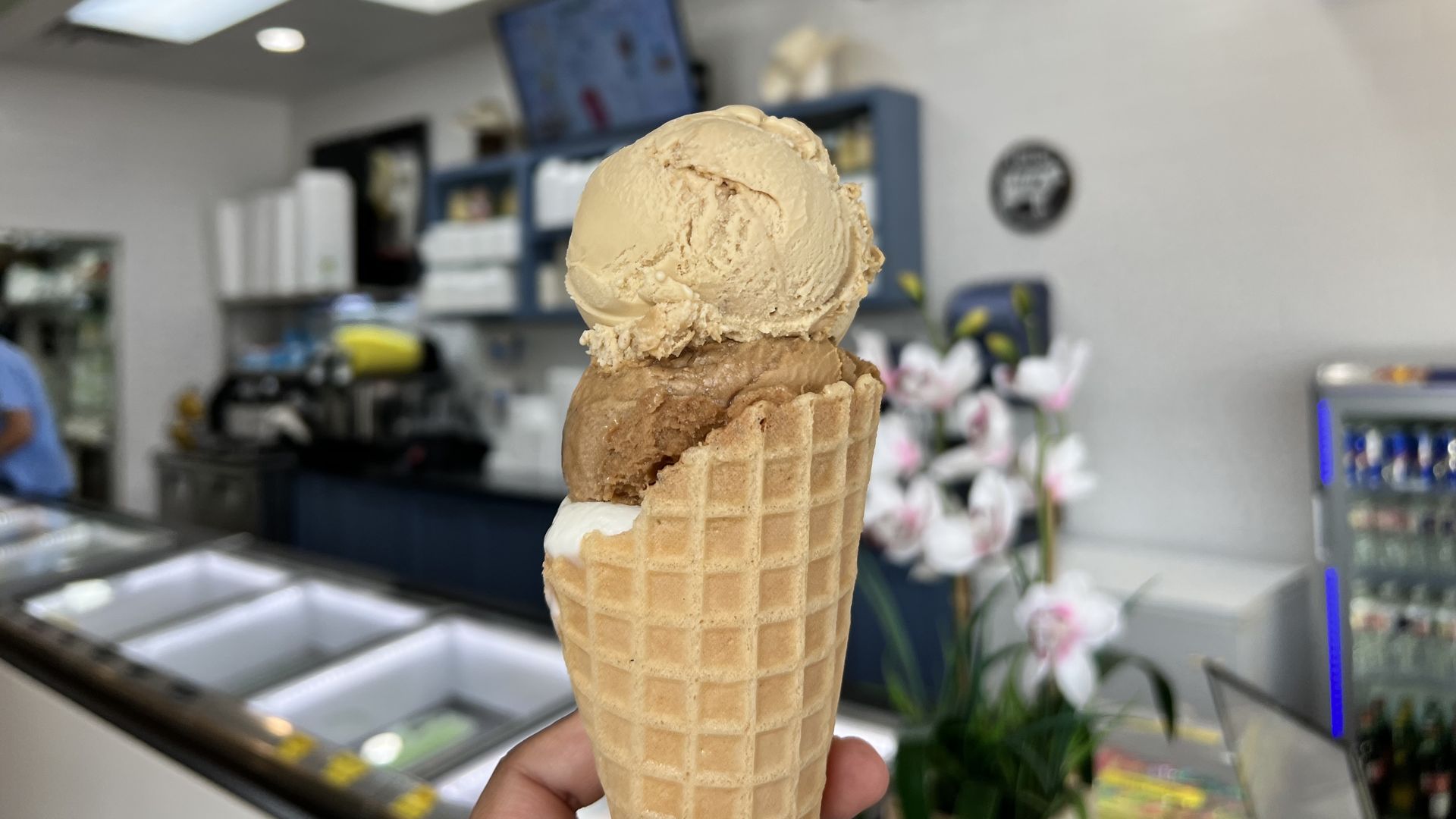 Photo of three scoops of ice cream on a cone. 