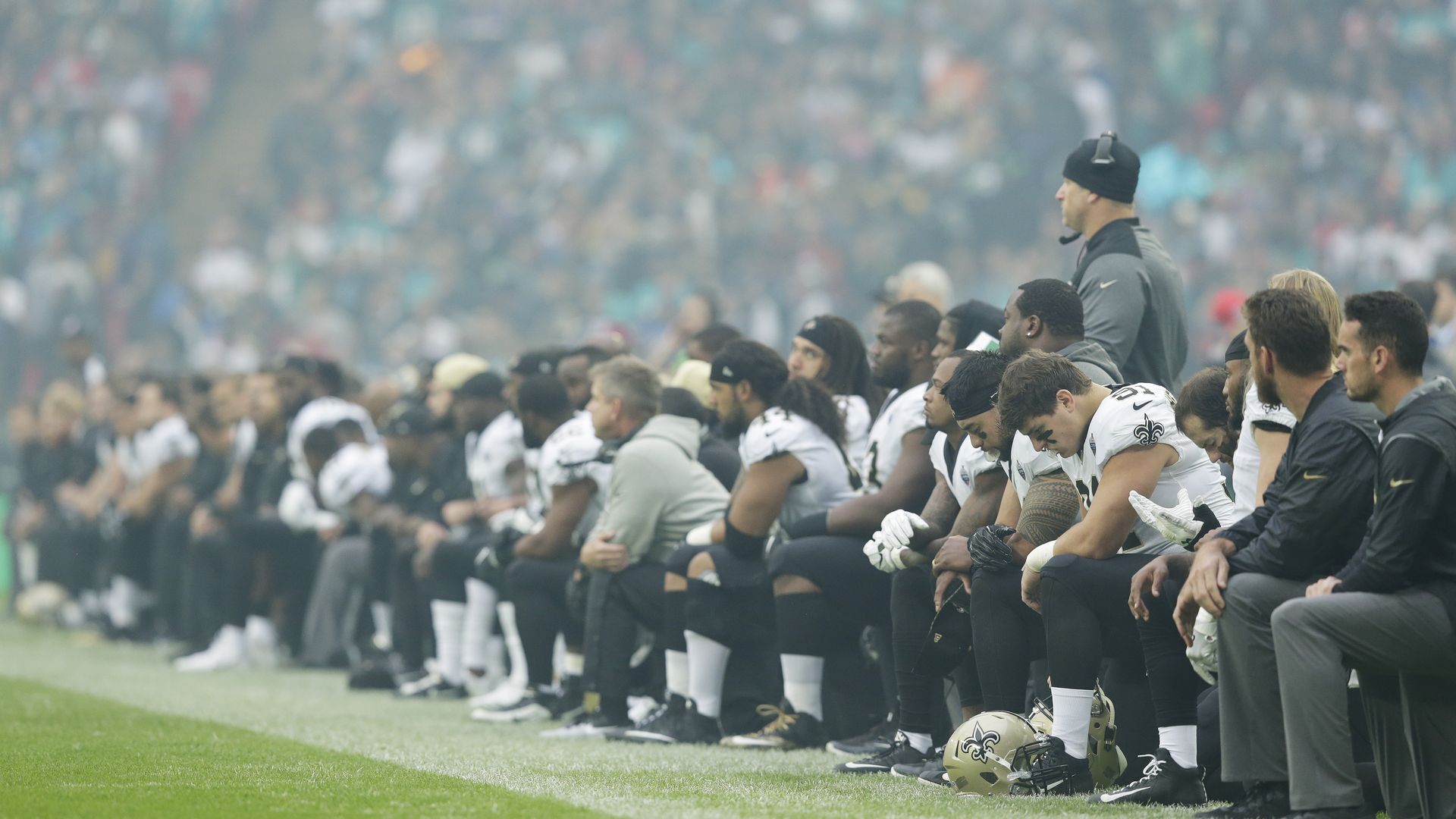 The New Orleans Saints players kneel before the anthem is played.