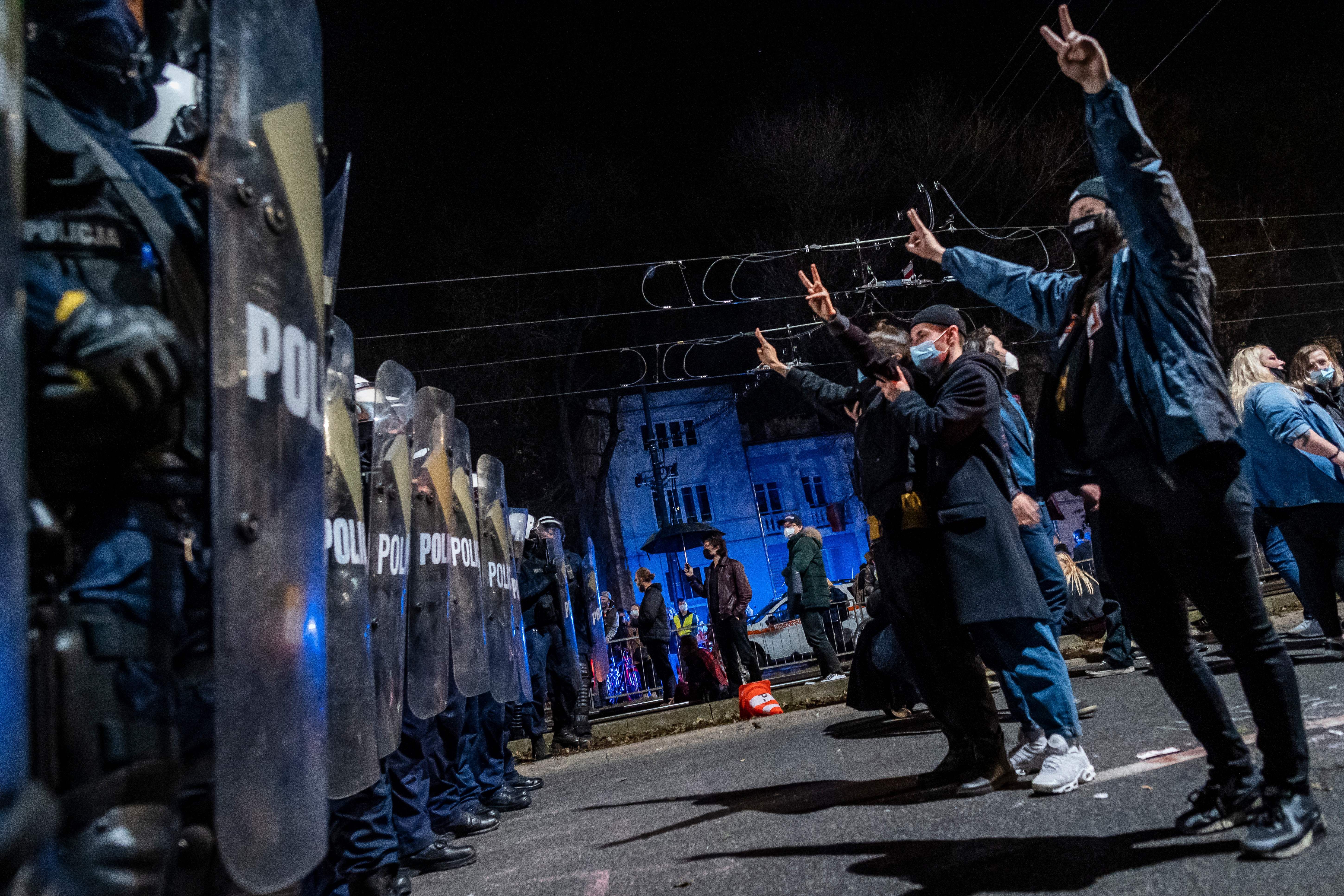 Protestors face off with riot police guarding the house of Jaroslaw Kaczynski.