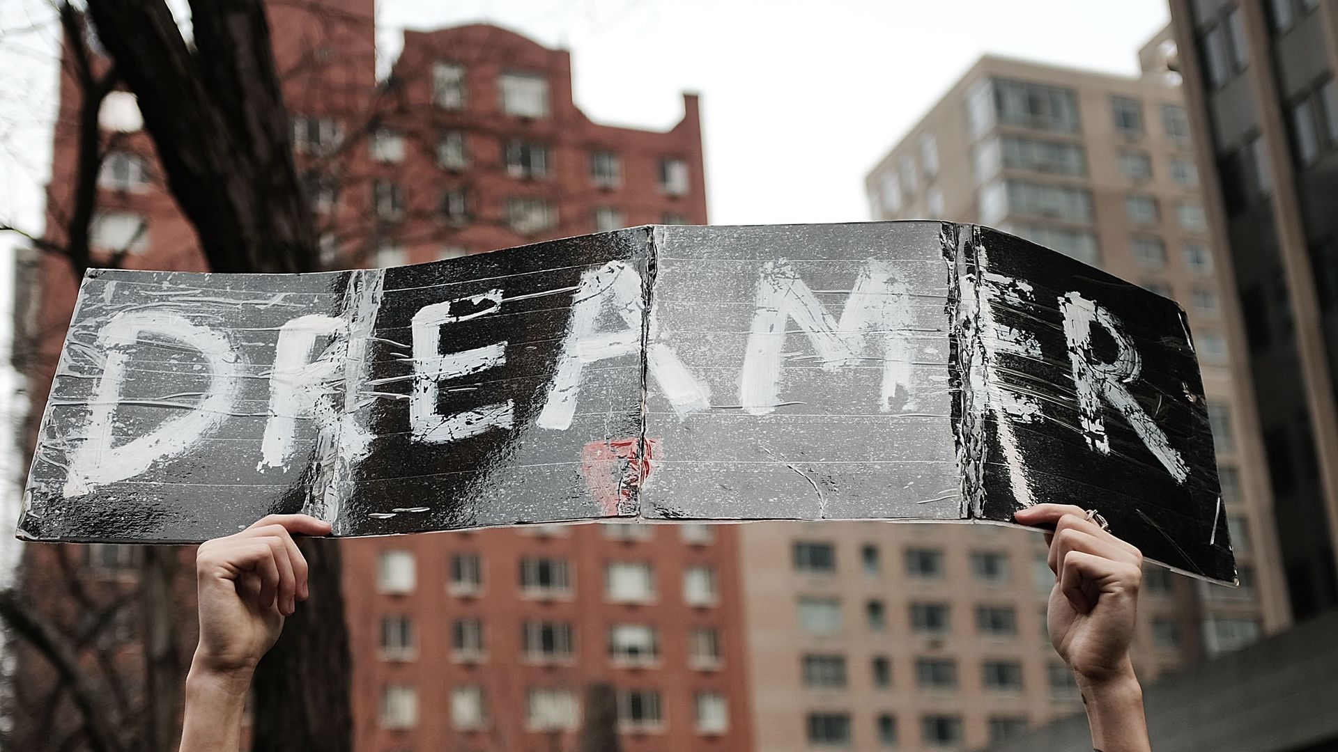 A man holds up a Dreamer sign