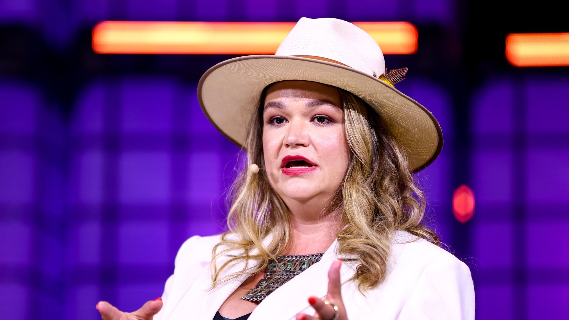 A person in a large white hat speaks