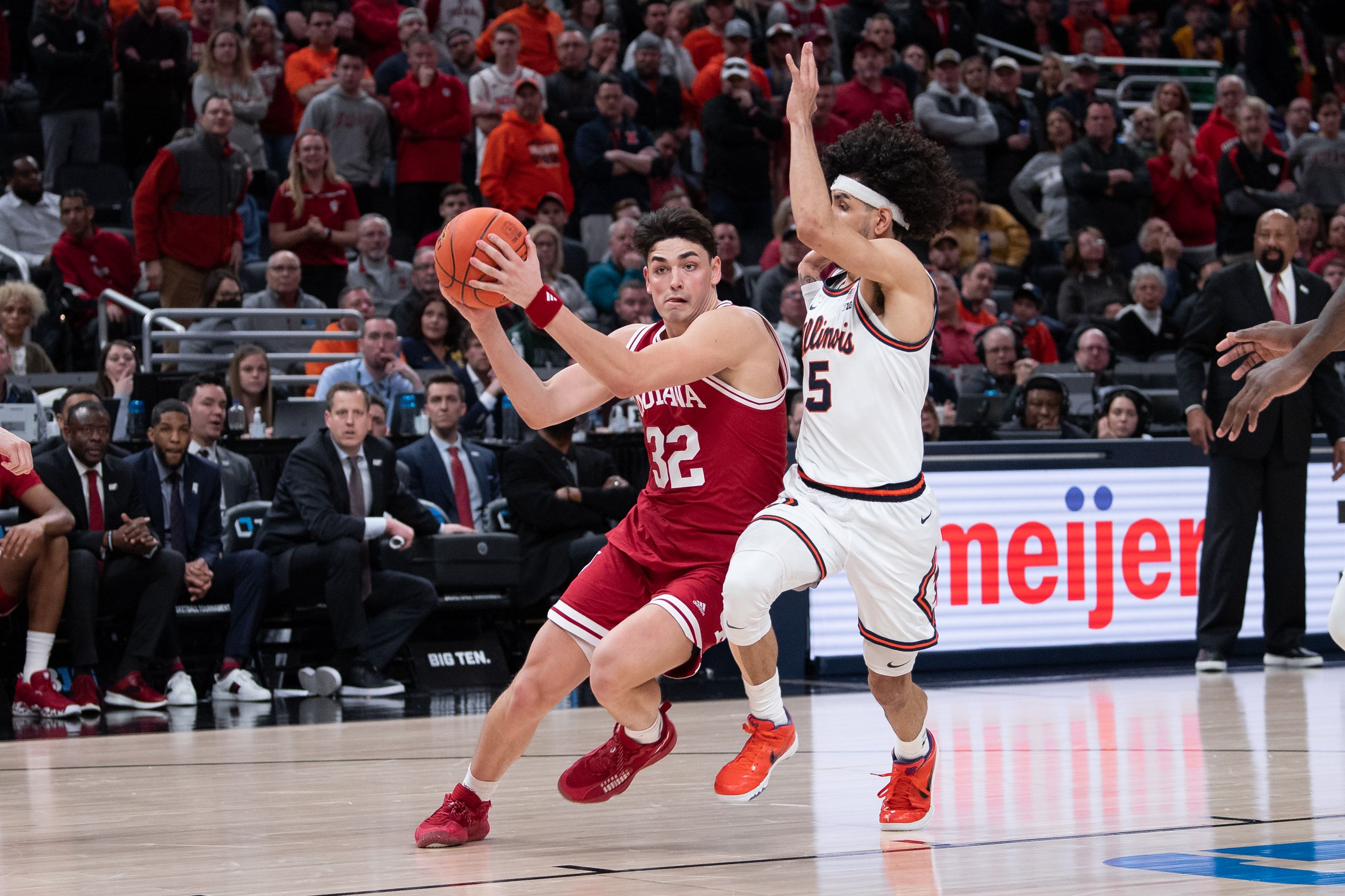 Photo of a man driving to the basket in a basketball game