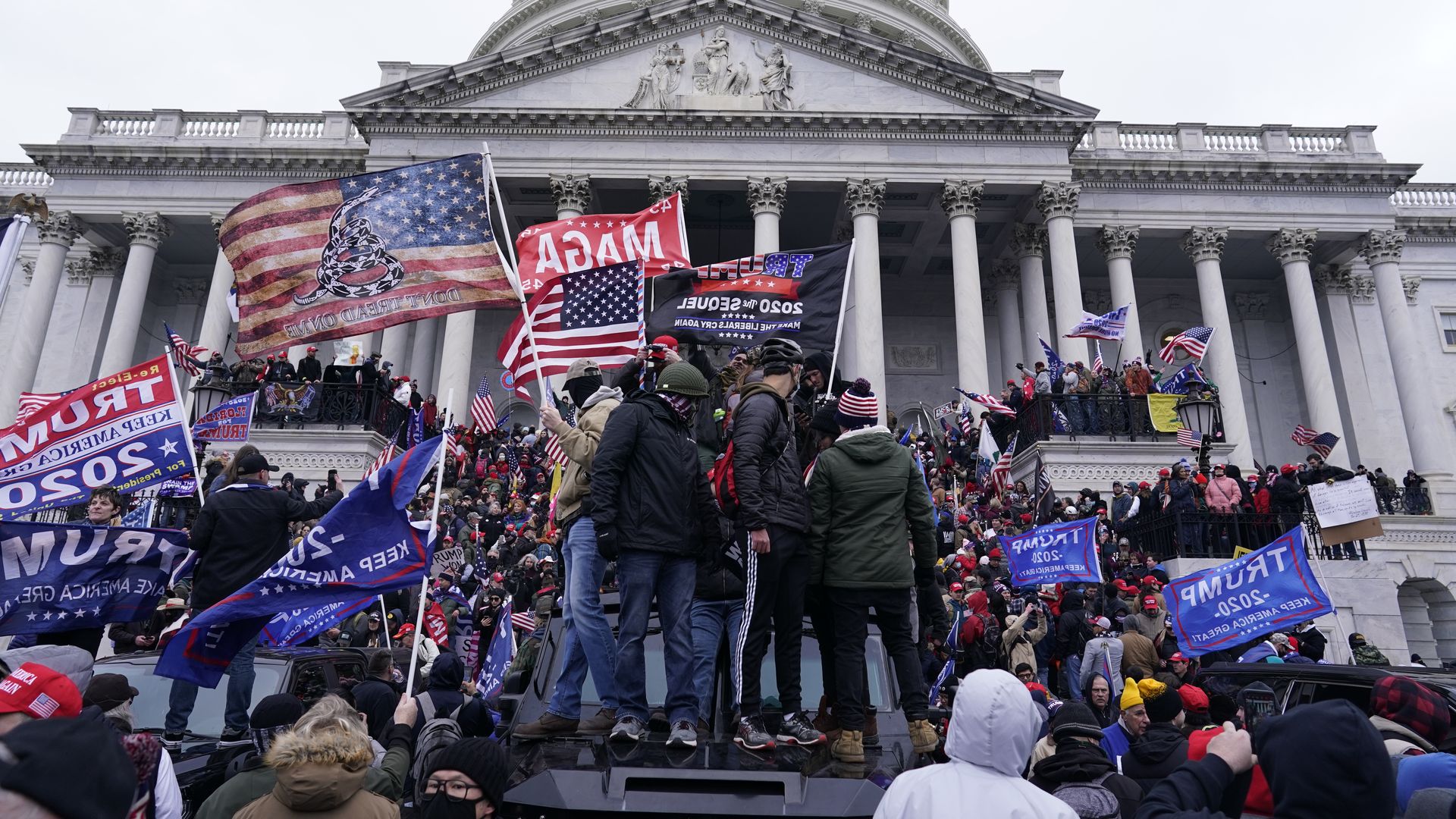 A mob of Trump supporters waving flags during the Jan. 6, 2021, attack on the Capitol.