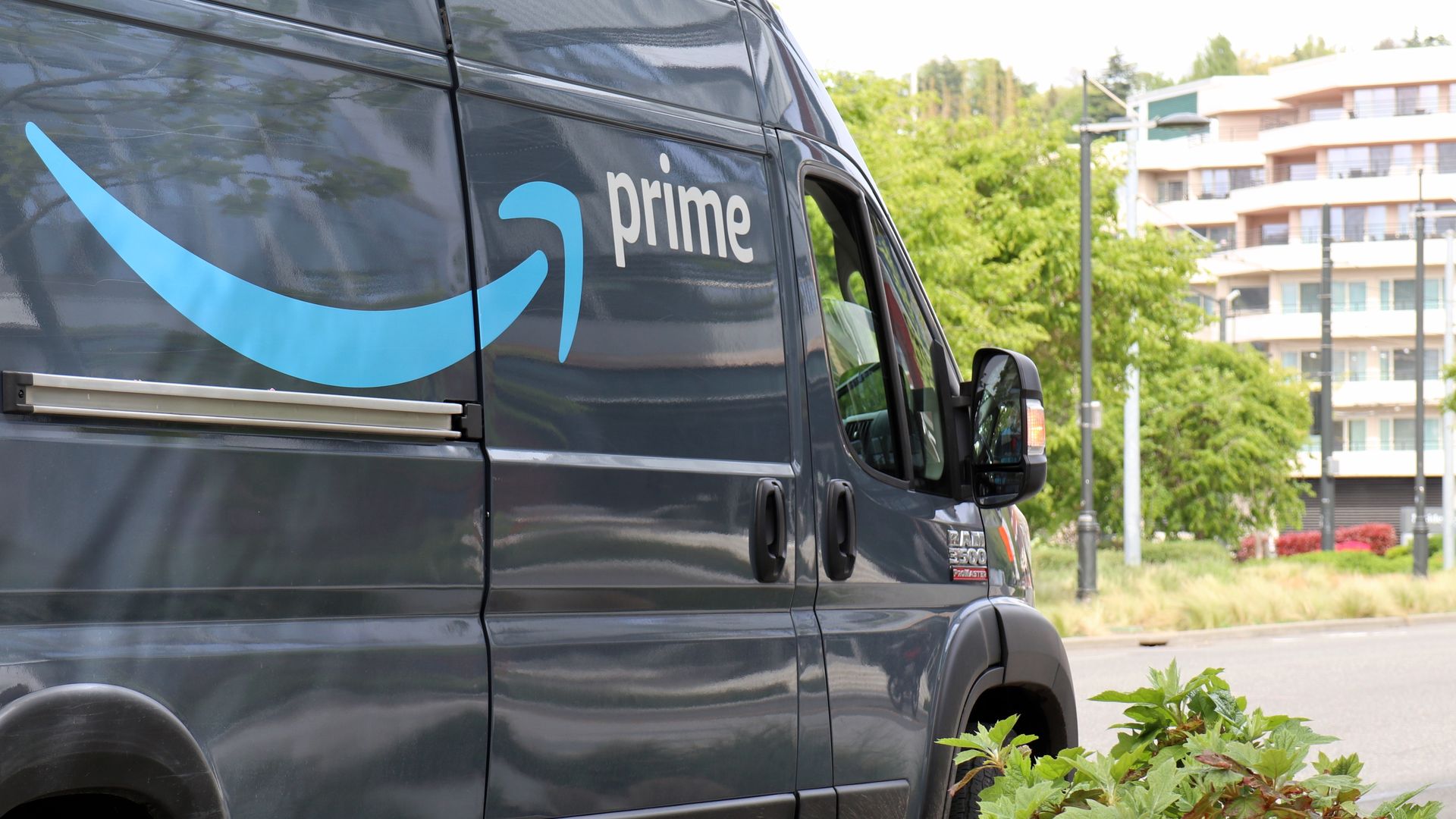 An Amazon Prime delivery truck is parked in front of a white multiplex in Seattle.