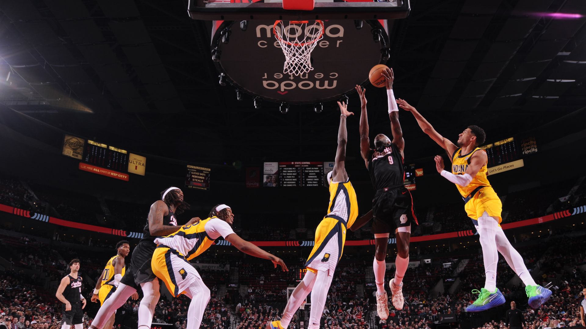 Jerami Grant, a player for the Portland Trail Blazers, drives to the basket surrounded by defenders in an NBA game.
