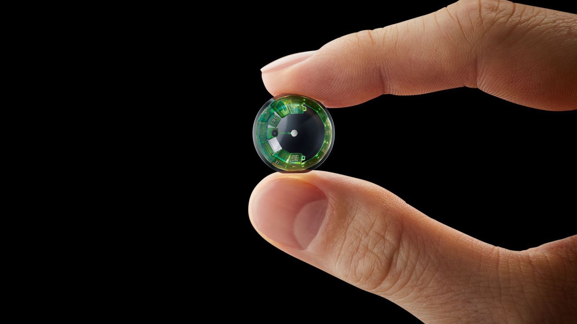 A prototype smart contacts lens from Mojo Vision is seen here being held between two fingers
