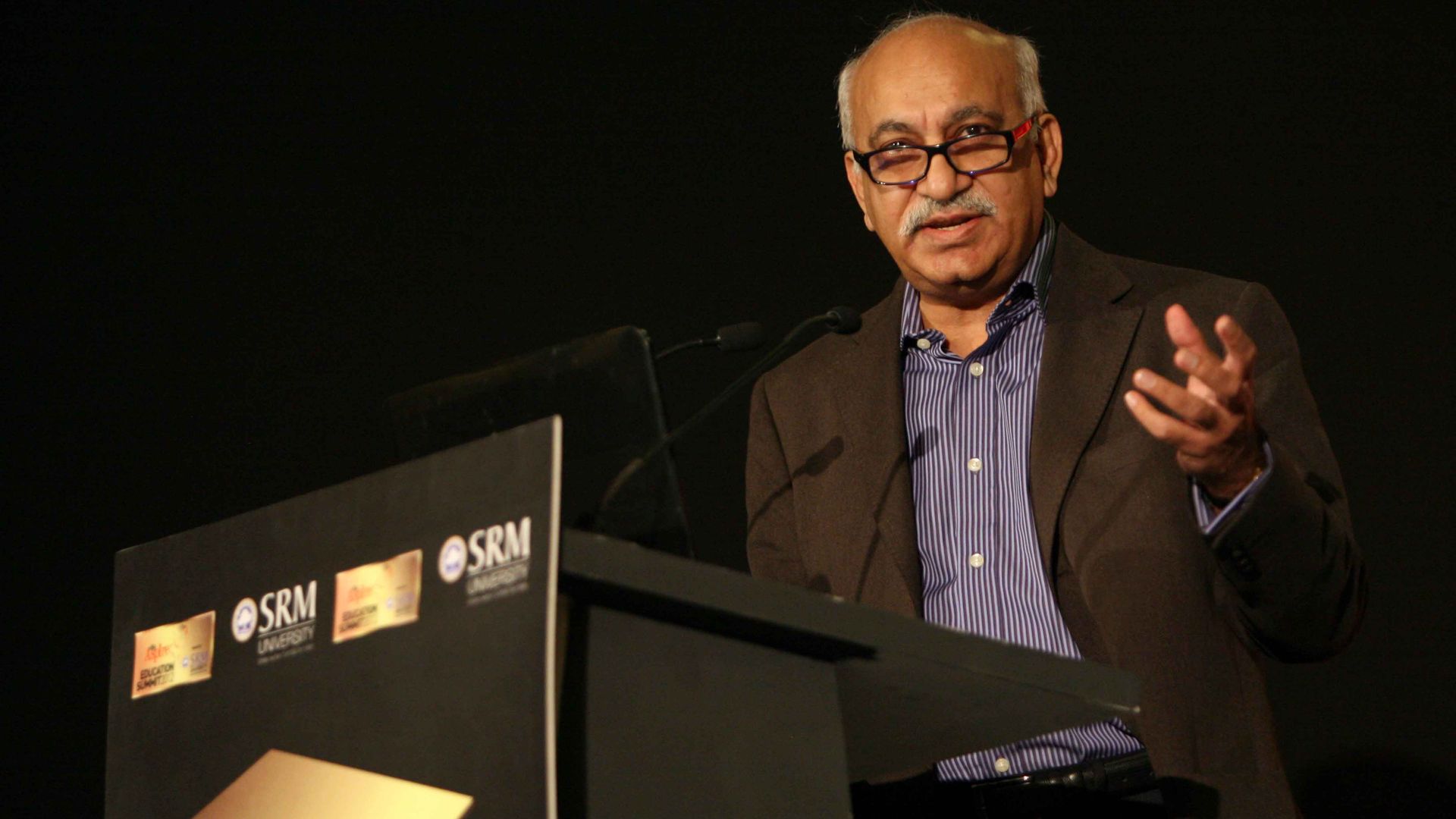 MJ Akbar talking at a podium.