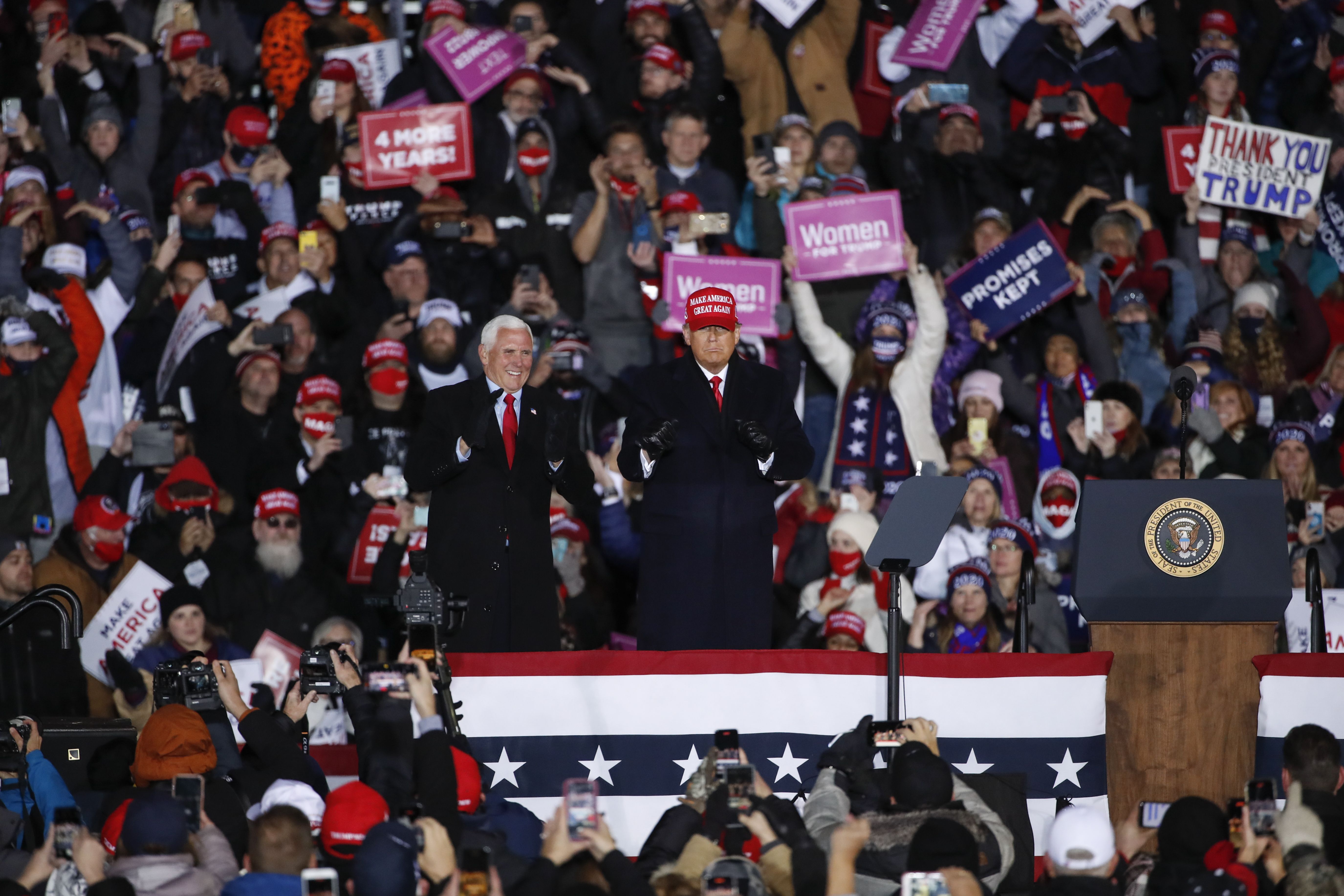 President Donald Trump (C) dances next to Vice President Mike Pence after speaking during a rally on November 3, 2020 in Grand Rapids, Michigan. 