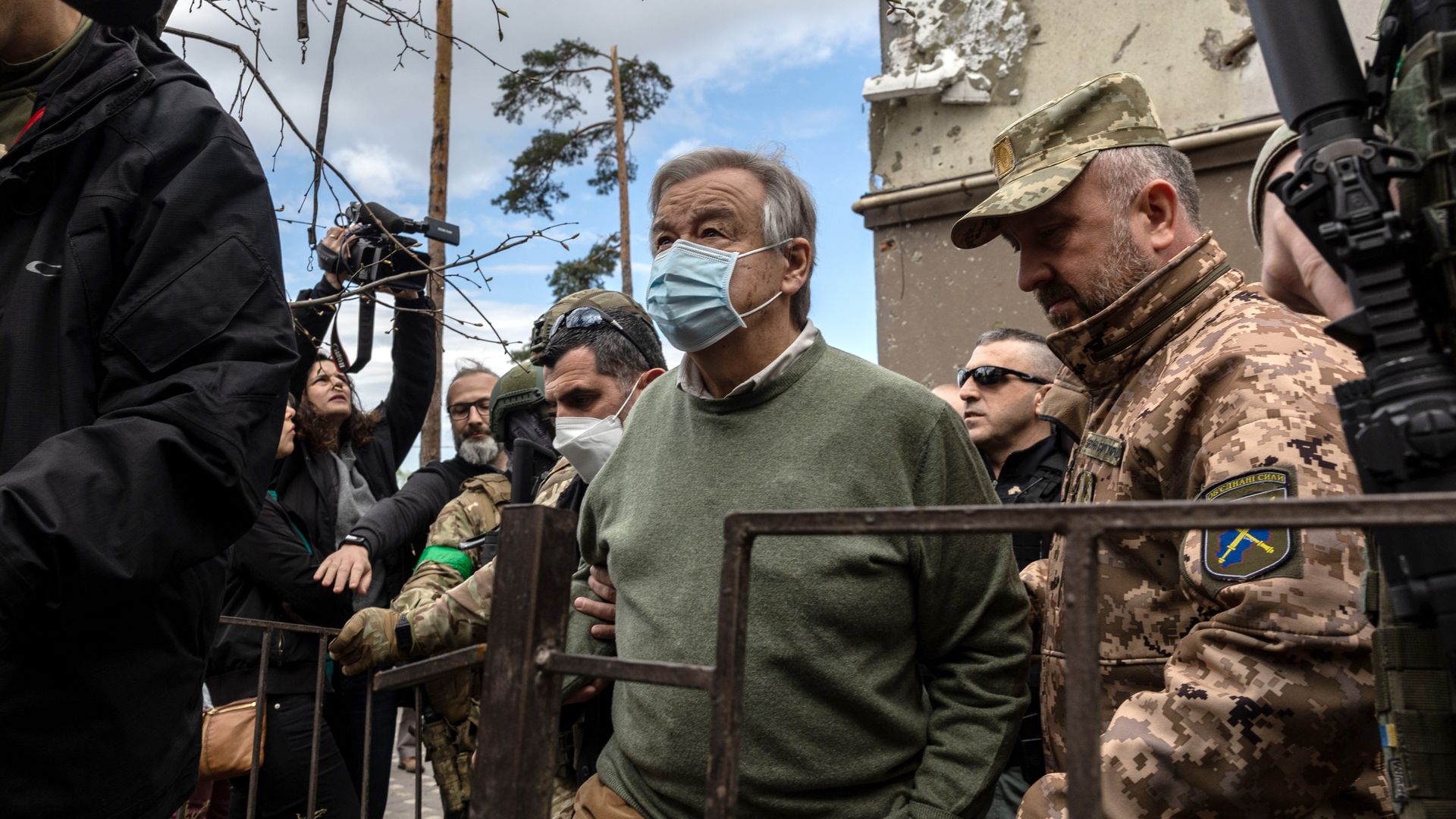 Picture of Antonio Guterres wearing a mask surrounded by security