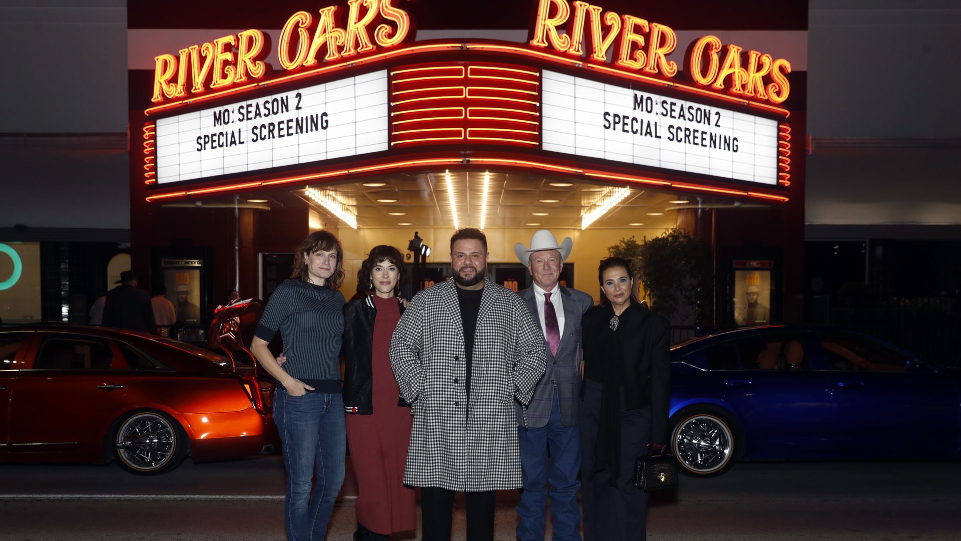 Five people standing in front of a lit movie theater marquee reading "MO: Season 2 Special Screening" at River Oaks, with two cars parked behind them at night.
