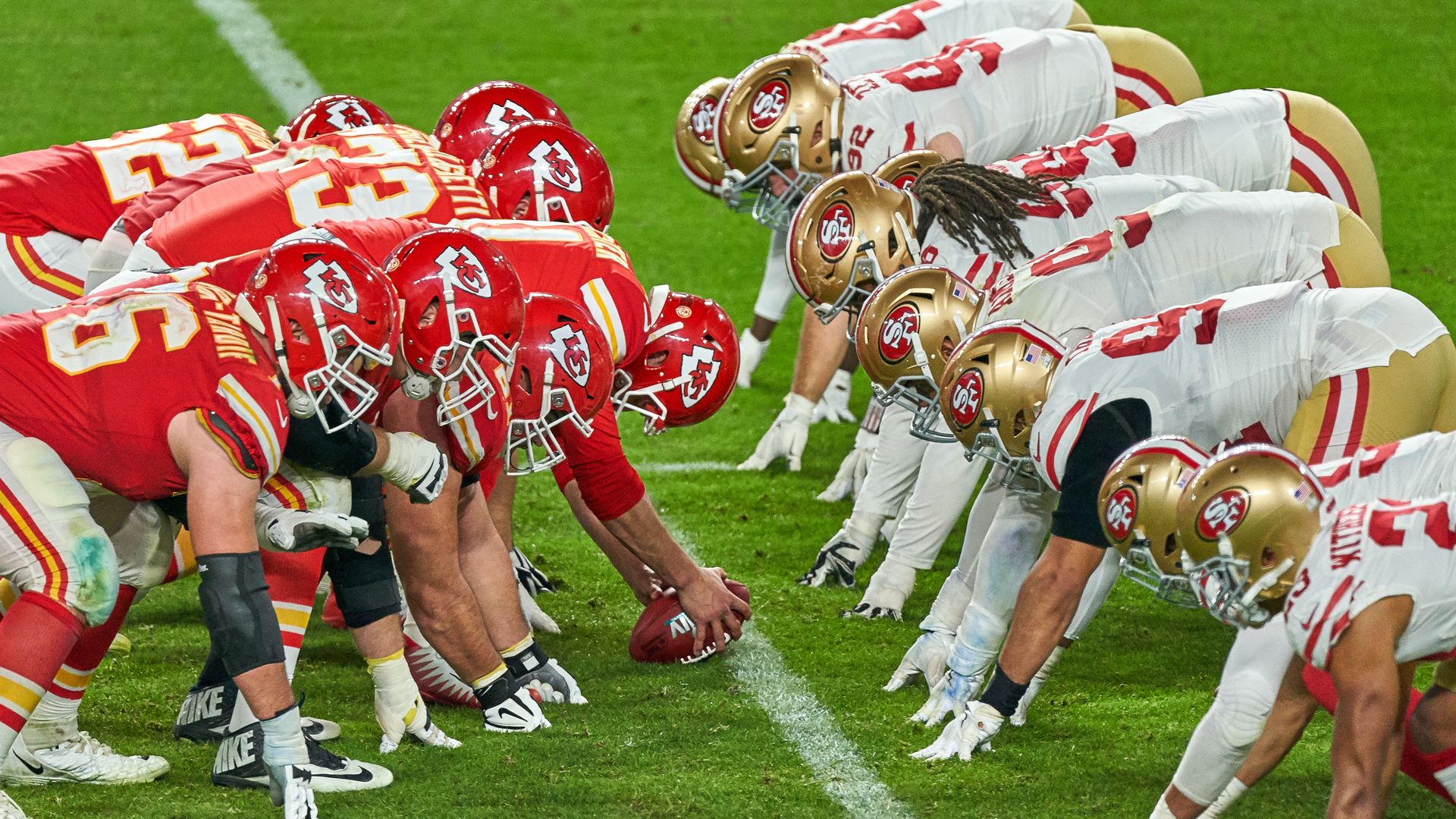 Two football teams line up across from each other on the line of scrimmage