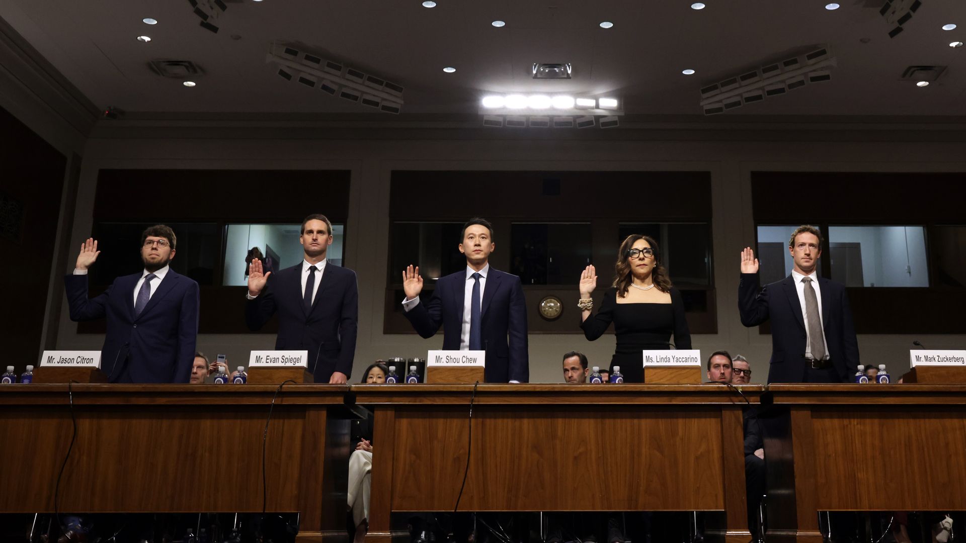 Five social media CEOs line up with right hands up to be sworn in for Senate testimony