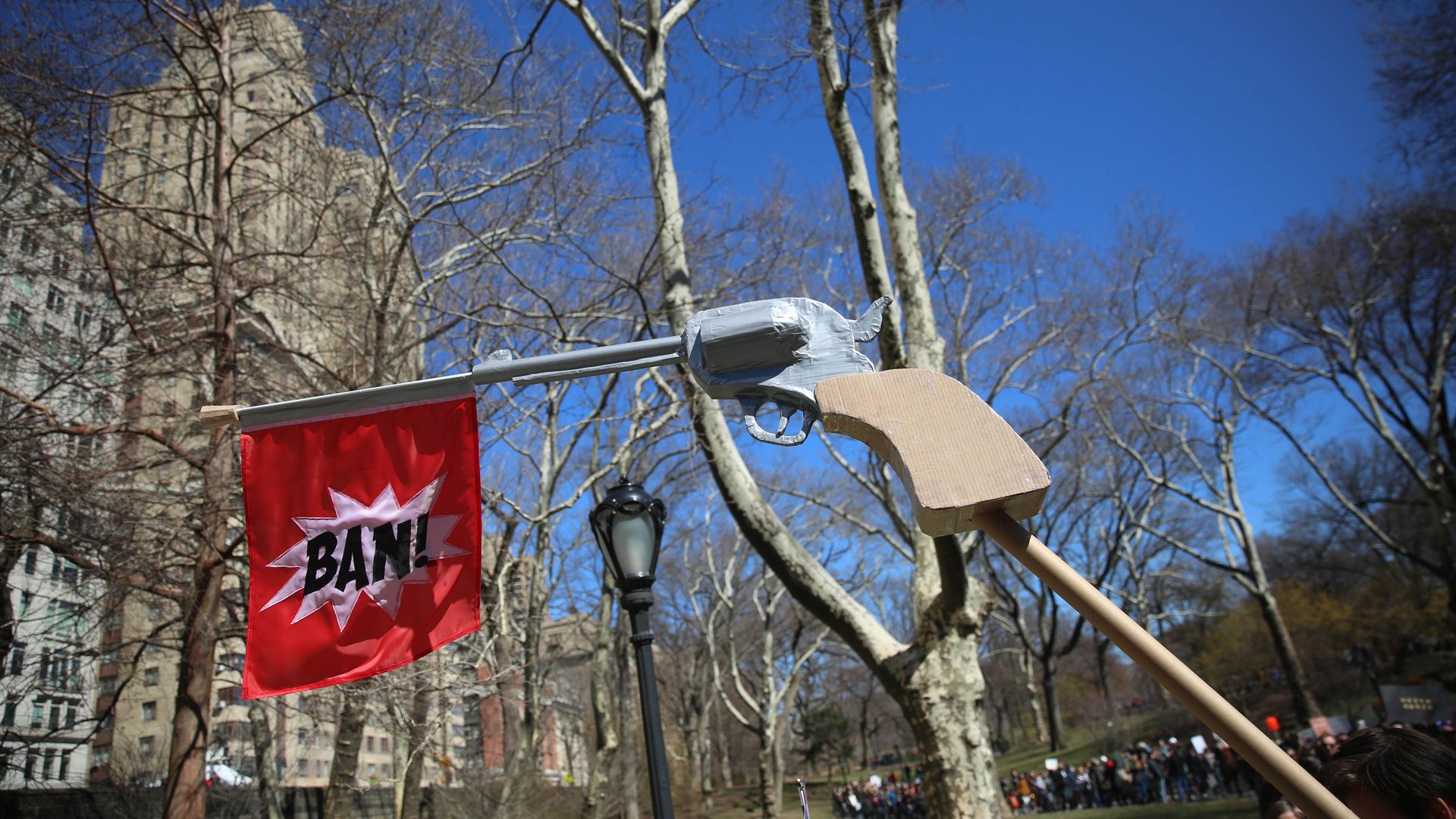 A hand pistol showing a bang flag is displayed during 'March For Our Lives' protest.