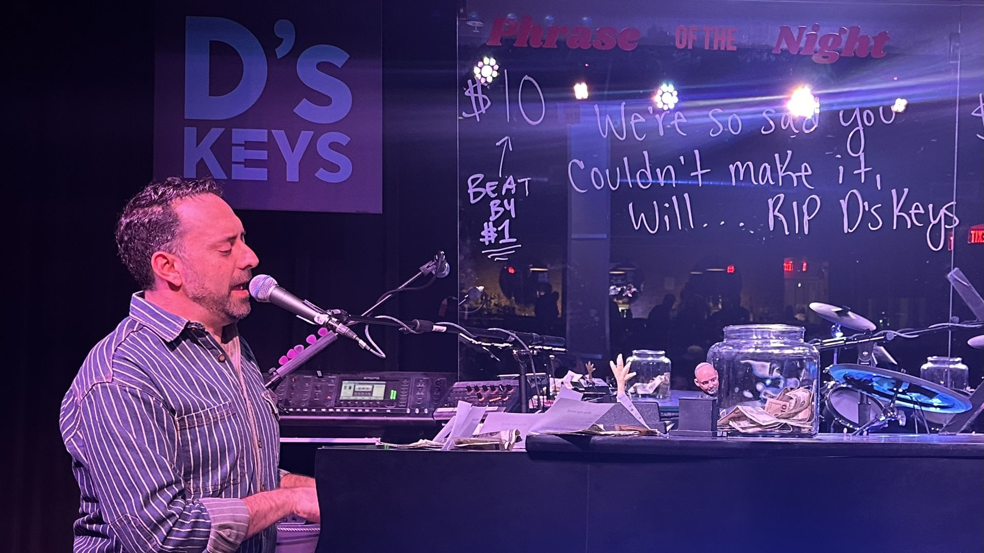 Co-owner Matt Nichols, a trained pianist, plays the piano on one of the last nights D's Keys is open. On the bakcground is a D's Keys sign and the mirror with a message written: "We're so sad you couldn't make it, Will...RIP D's Keys."