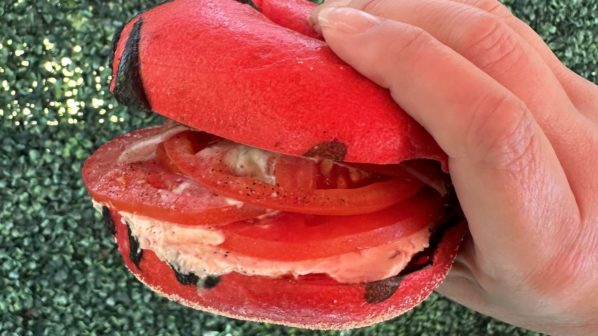 a bright red bagel loaded with tomatoes 