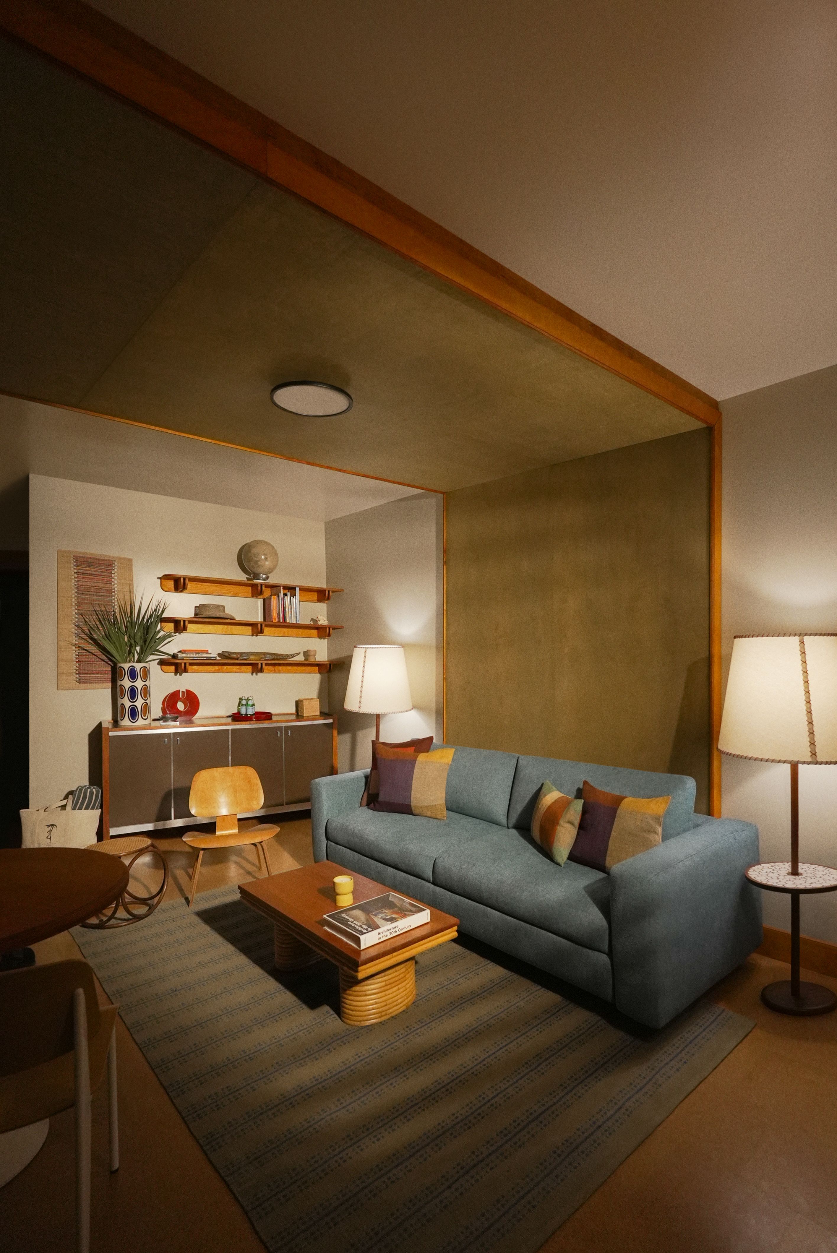 A living room area has a blue couch at the center.