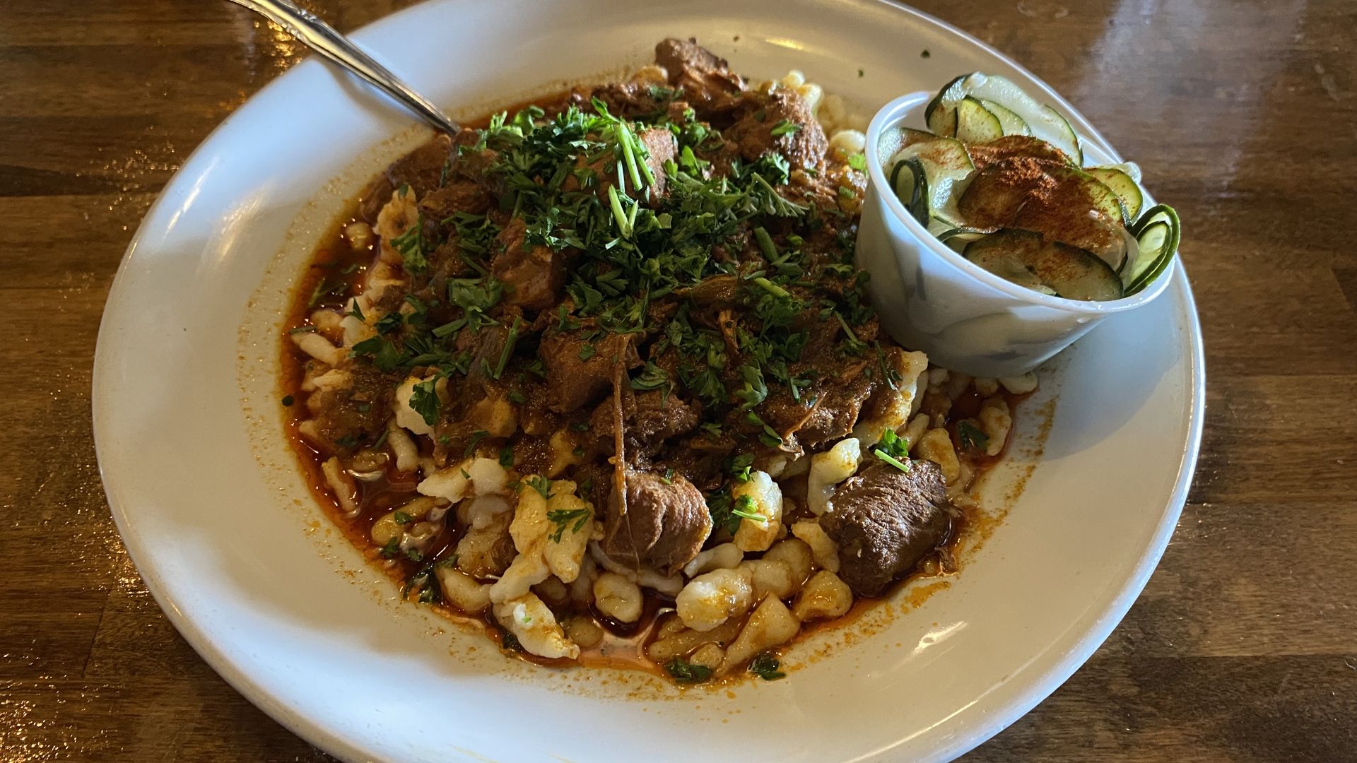 A bowl filled with pasta topped with stew. 