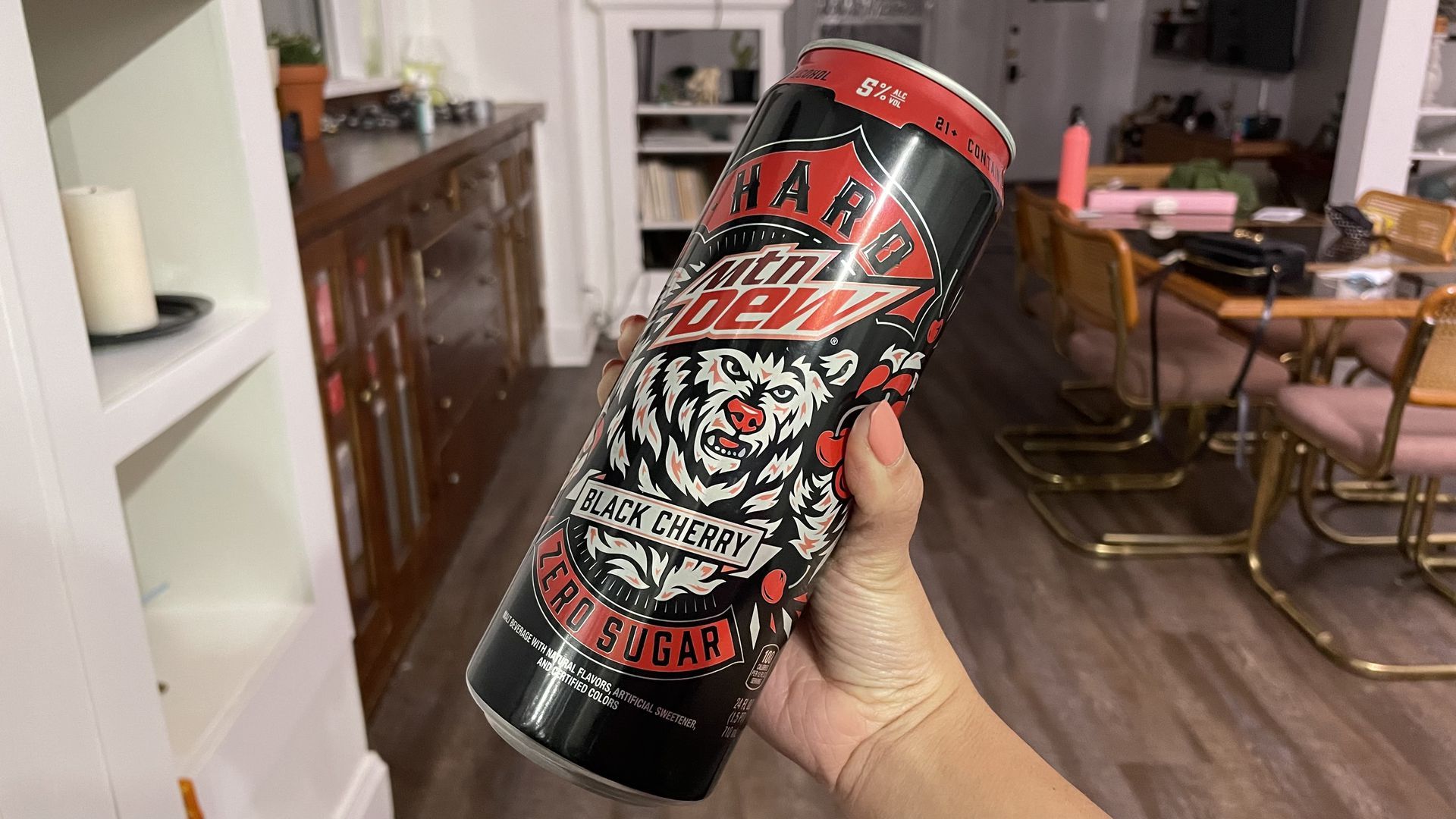 a hand holds the new hard mountain dew can