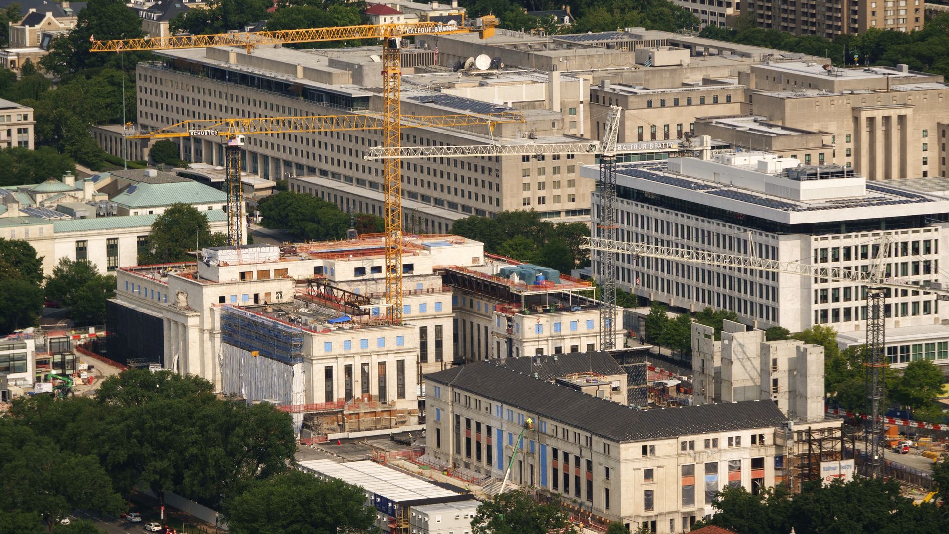 A bird's eye view of the Federal Reserve building being renovated with cranes in the sky