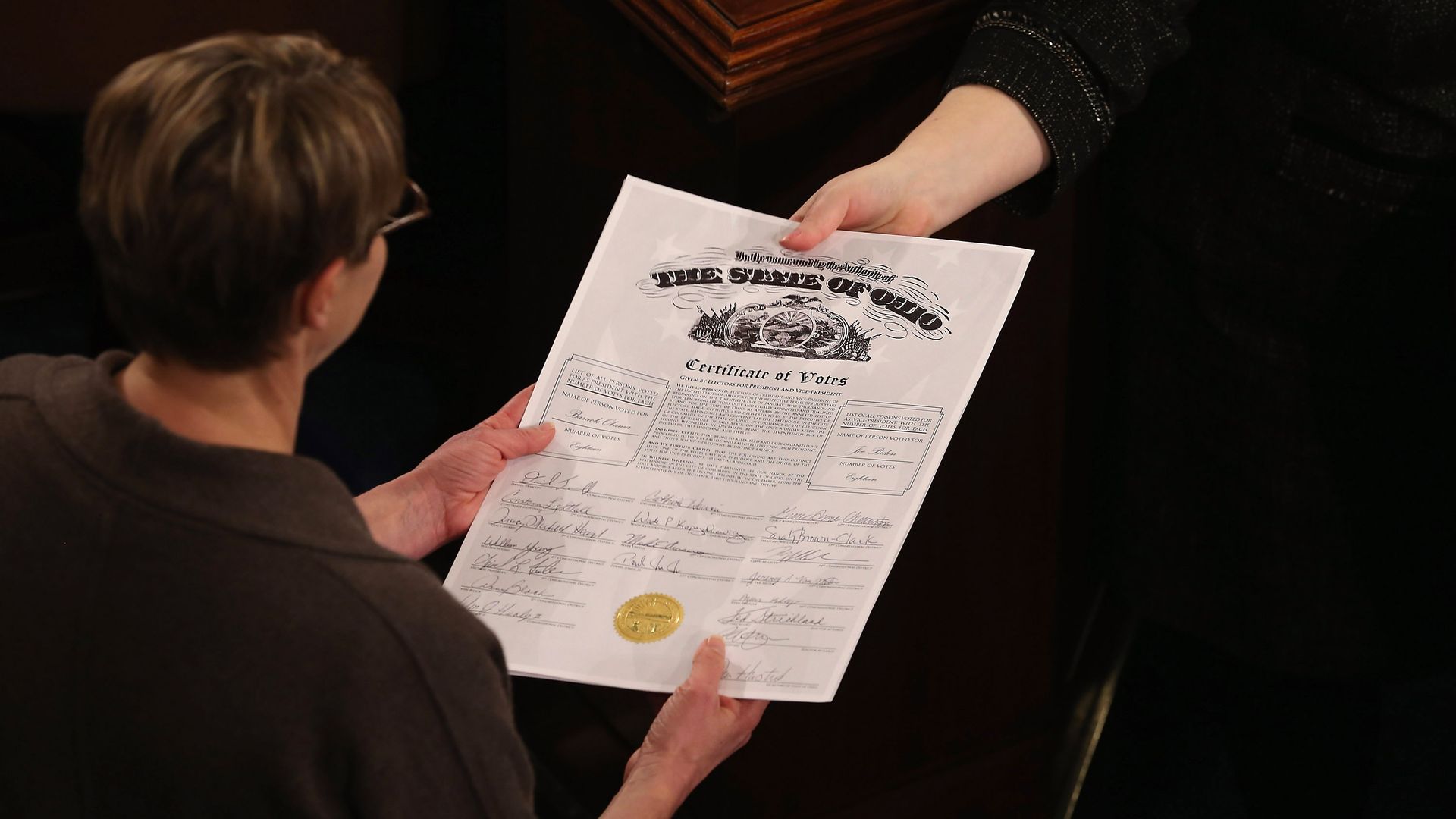 A large piece of paper is handed over.