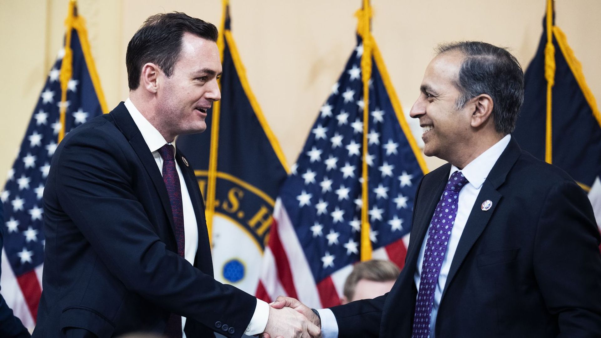 Reps. Mike Gallagher and Raja Krishnamoorth shaking hands.
