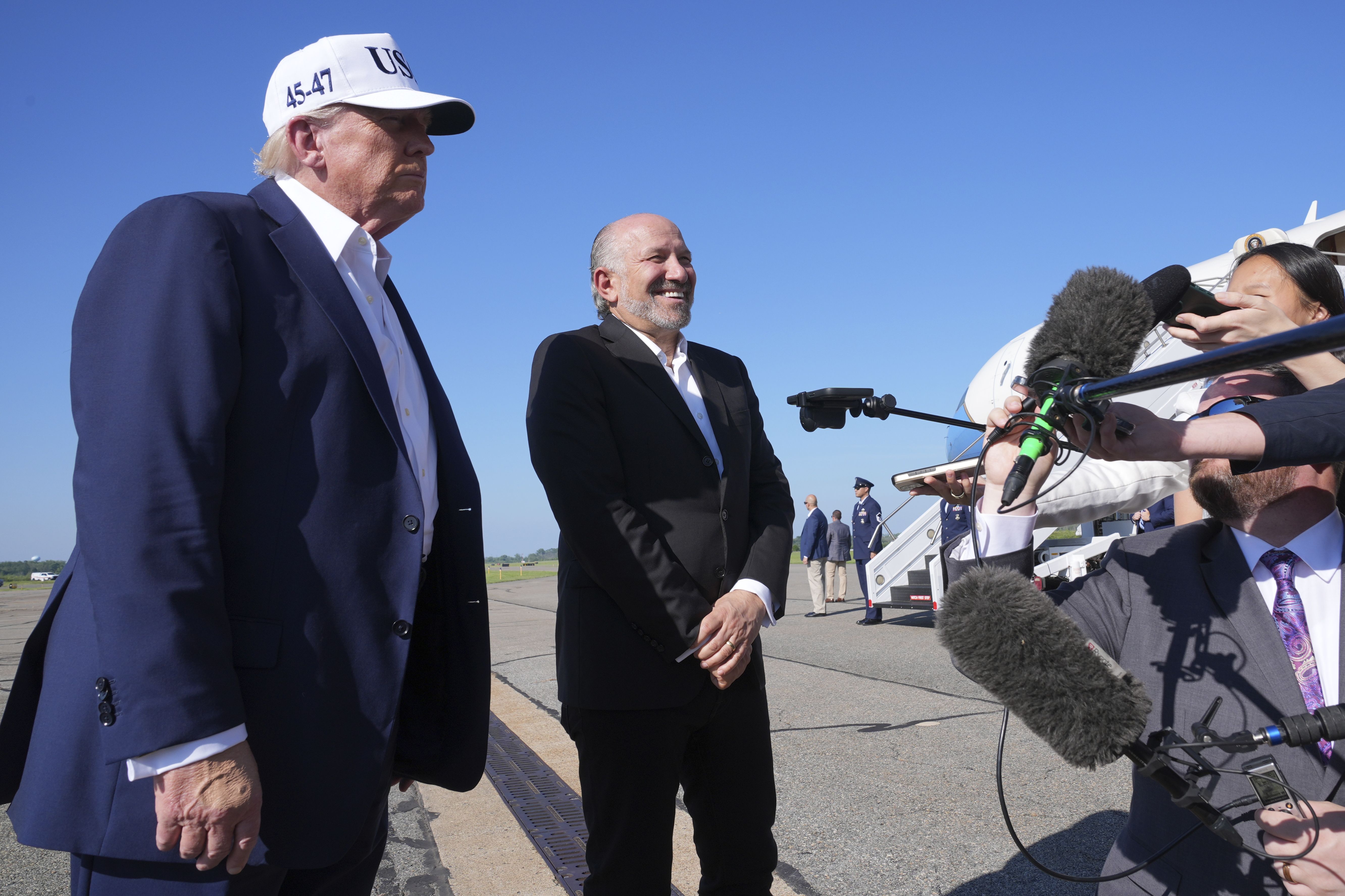 President Trump and Commerce Secretary Howard Lutnick talk to reporters before boarding Air Force One in Morristown, N.J., on July 6.