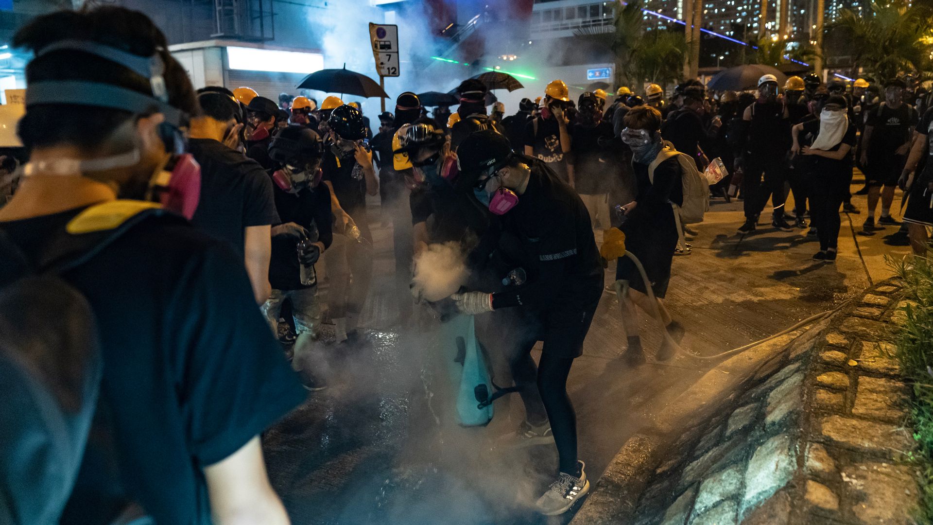 Protesters attempt to put off a tear gas canister during a clash with police in Wong Tai Sin district on August 24, 2019 in Hong Kong