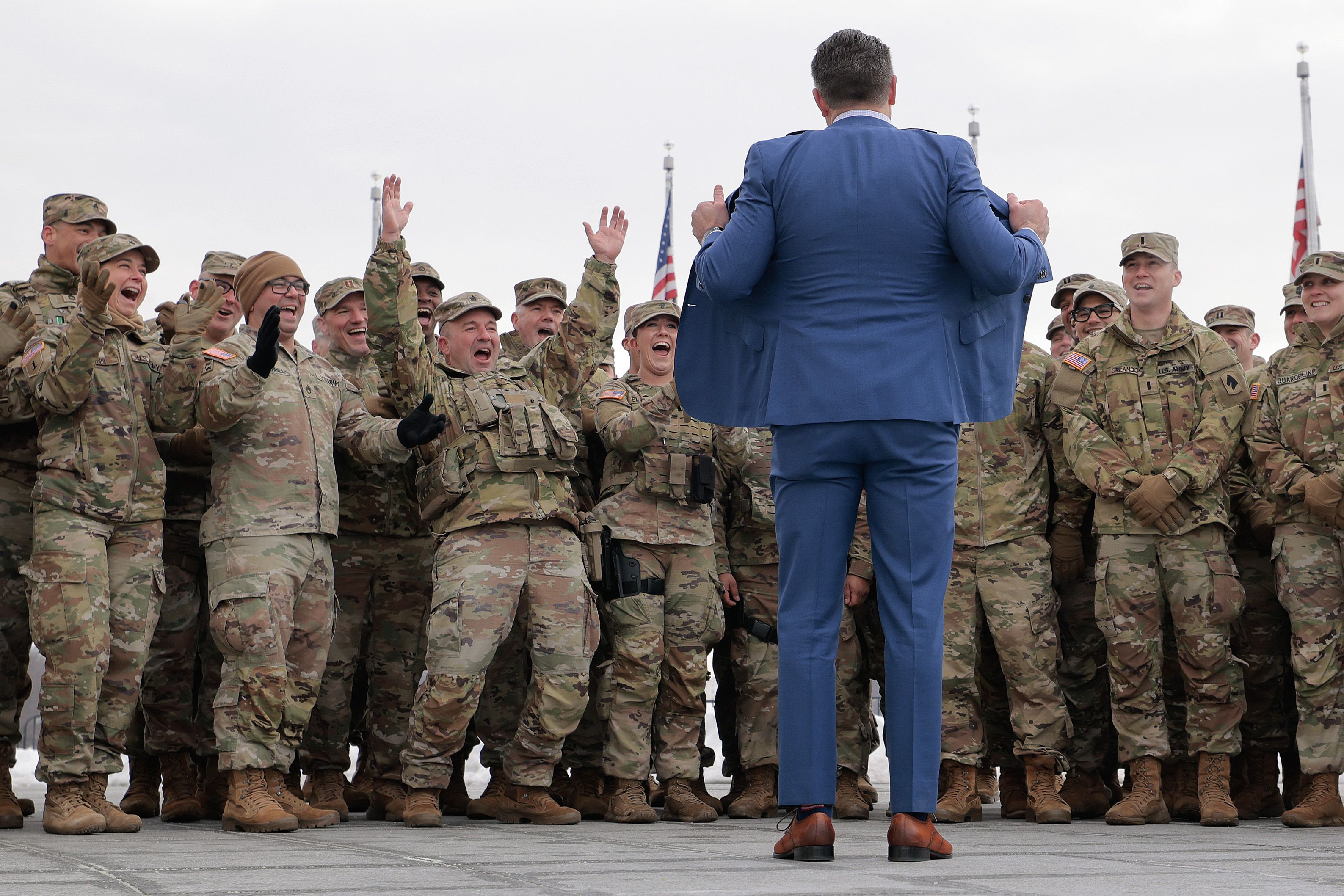National Guard troops react as Secretary of War Pete Hegseth opens his suit jacket to show the U.S. flag lining following a re-enlistment ceremony at the Washington Monument on February 06, 2026 in Washington, DC. Braving sub-freezing temperatures, Hegseth led a re-enlistment ceremony for 105 Nation
