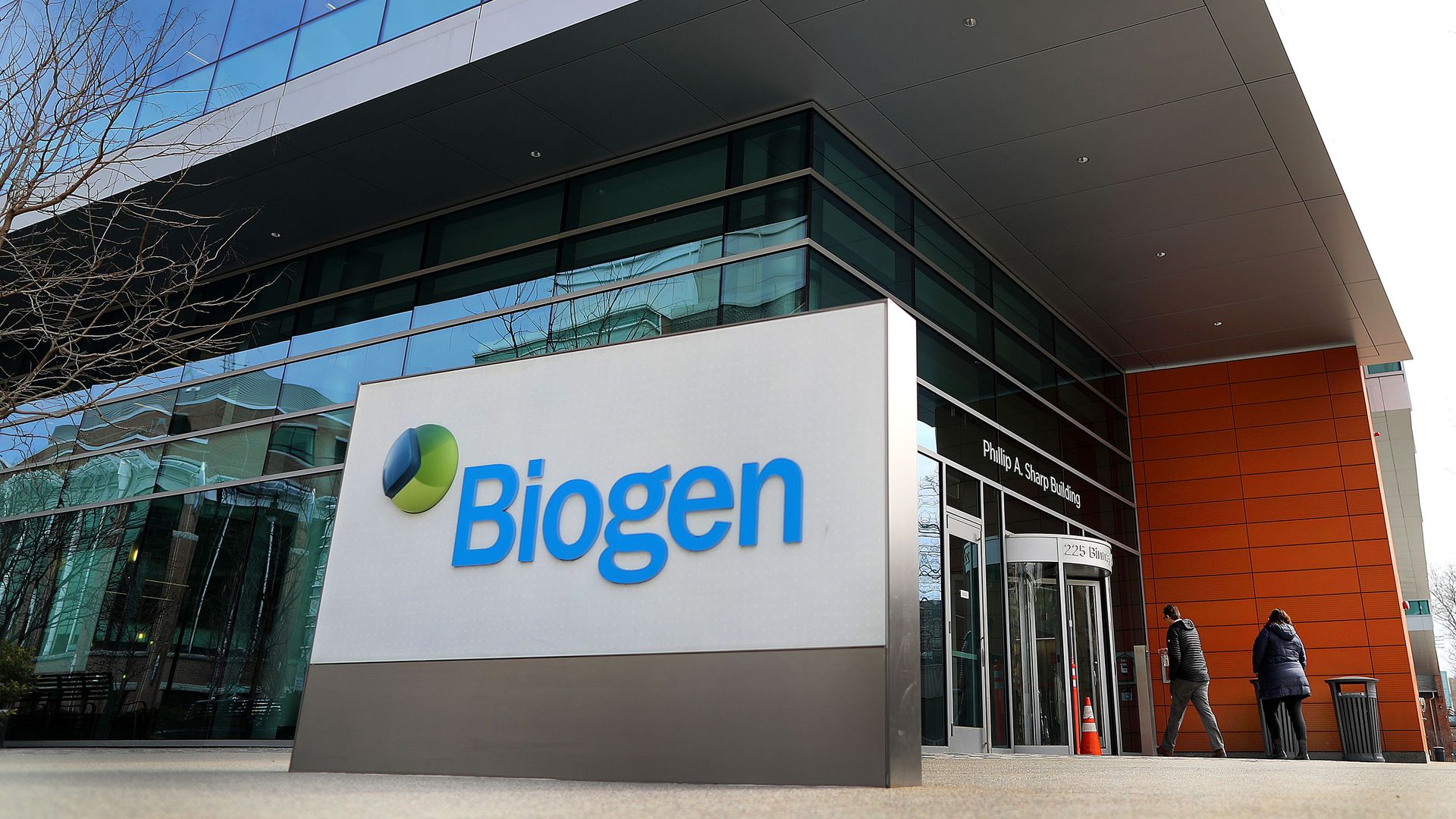 A Biogen sign in front of the Biogen headquarters building.
