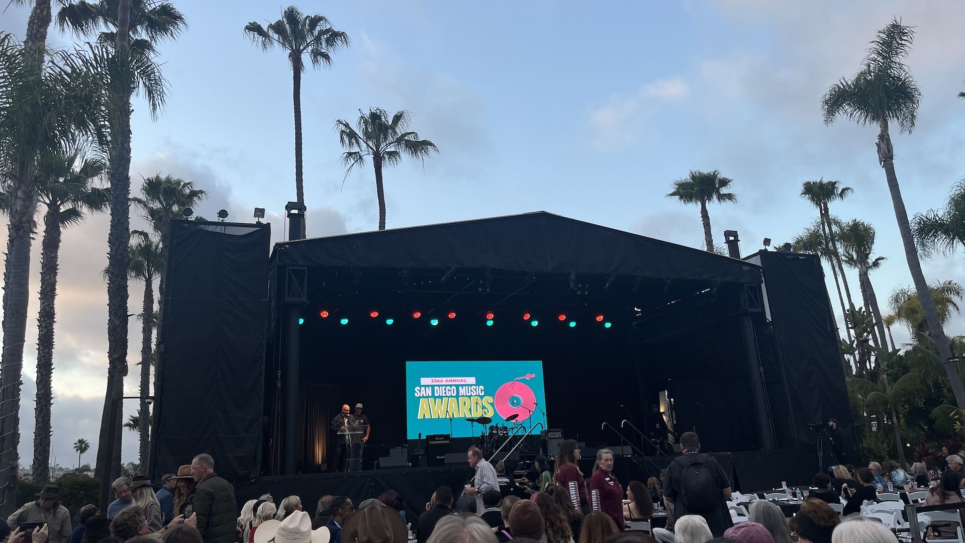 An outdoor concert venue with palm tres.