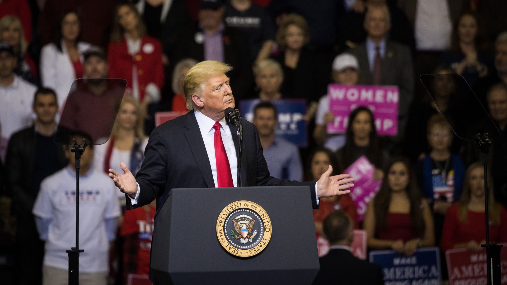President Trump behind a podium at a trump rally 