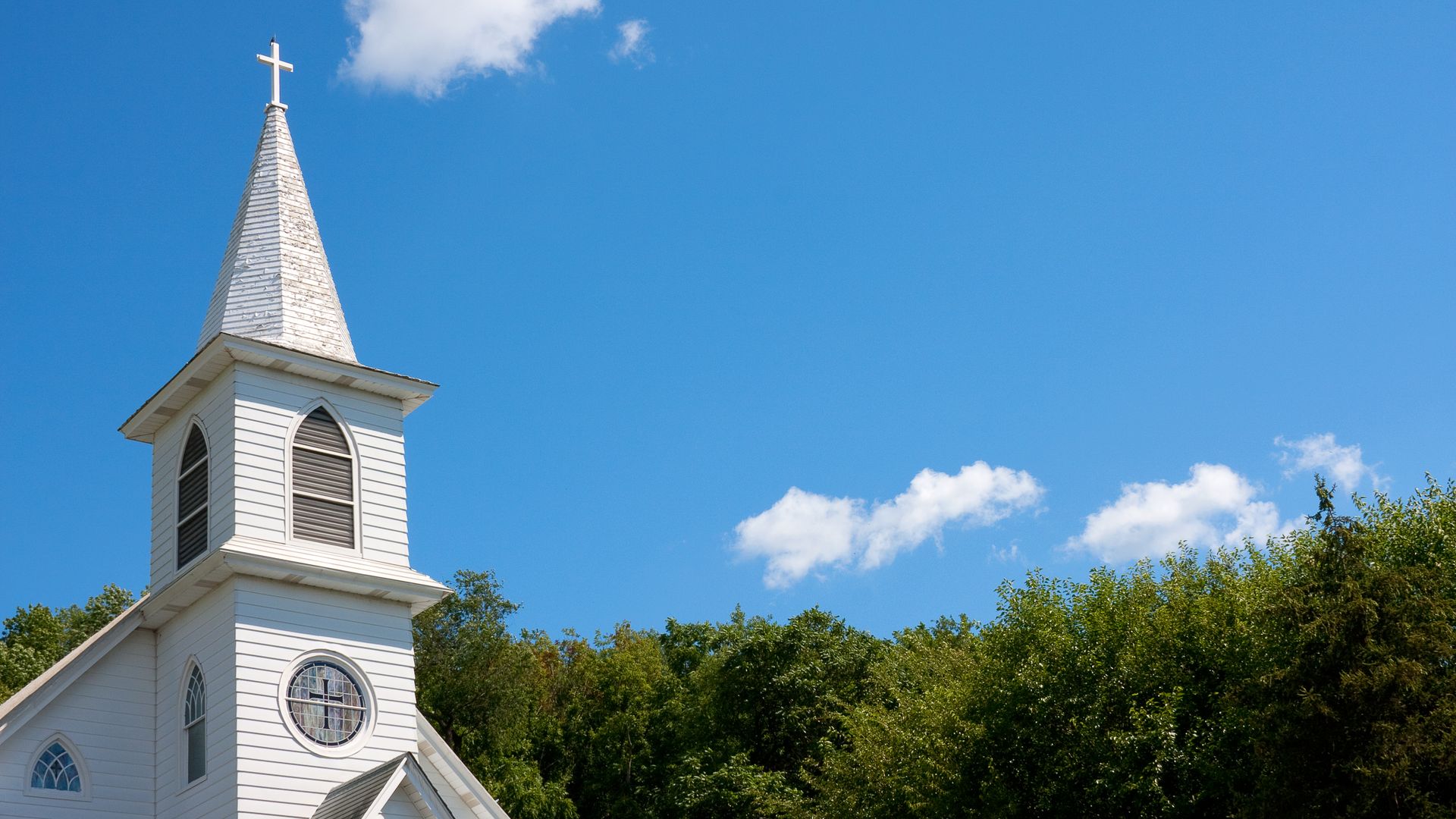 This is an image of a white church against a blue sky. 