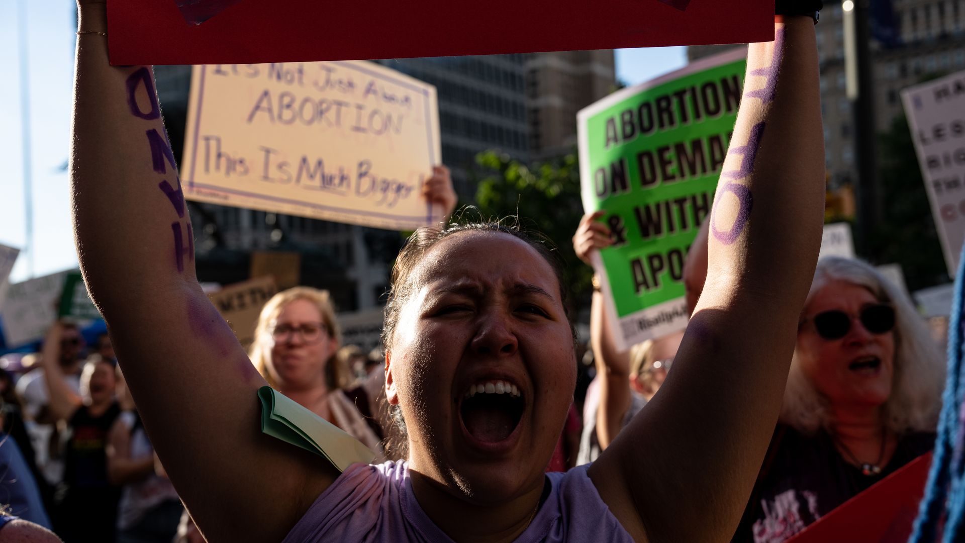 A woman yells while holding up a protest sign outside Philadelphia City Hall on Friday.