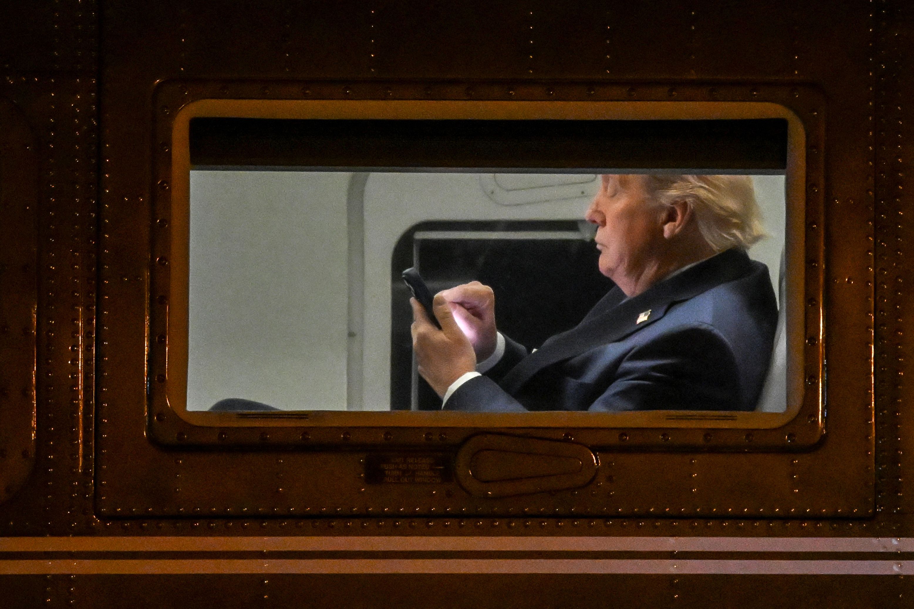 Trump looks at a phone