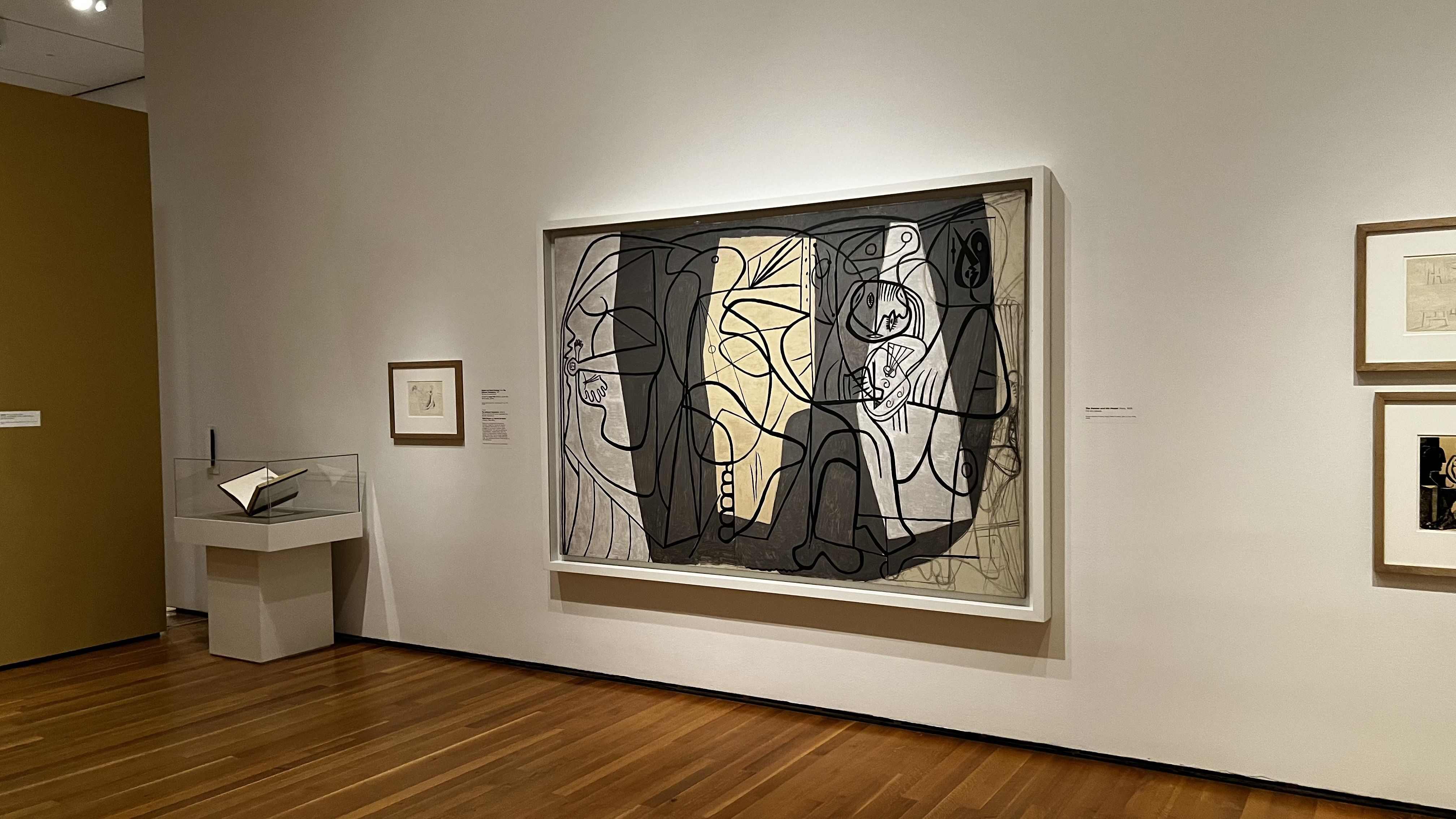 Picasso's "Artist and His Model" hangs on a wall. 