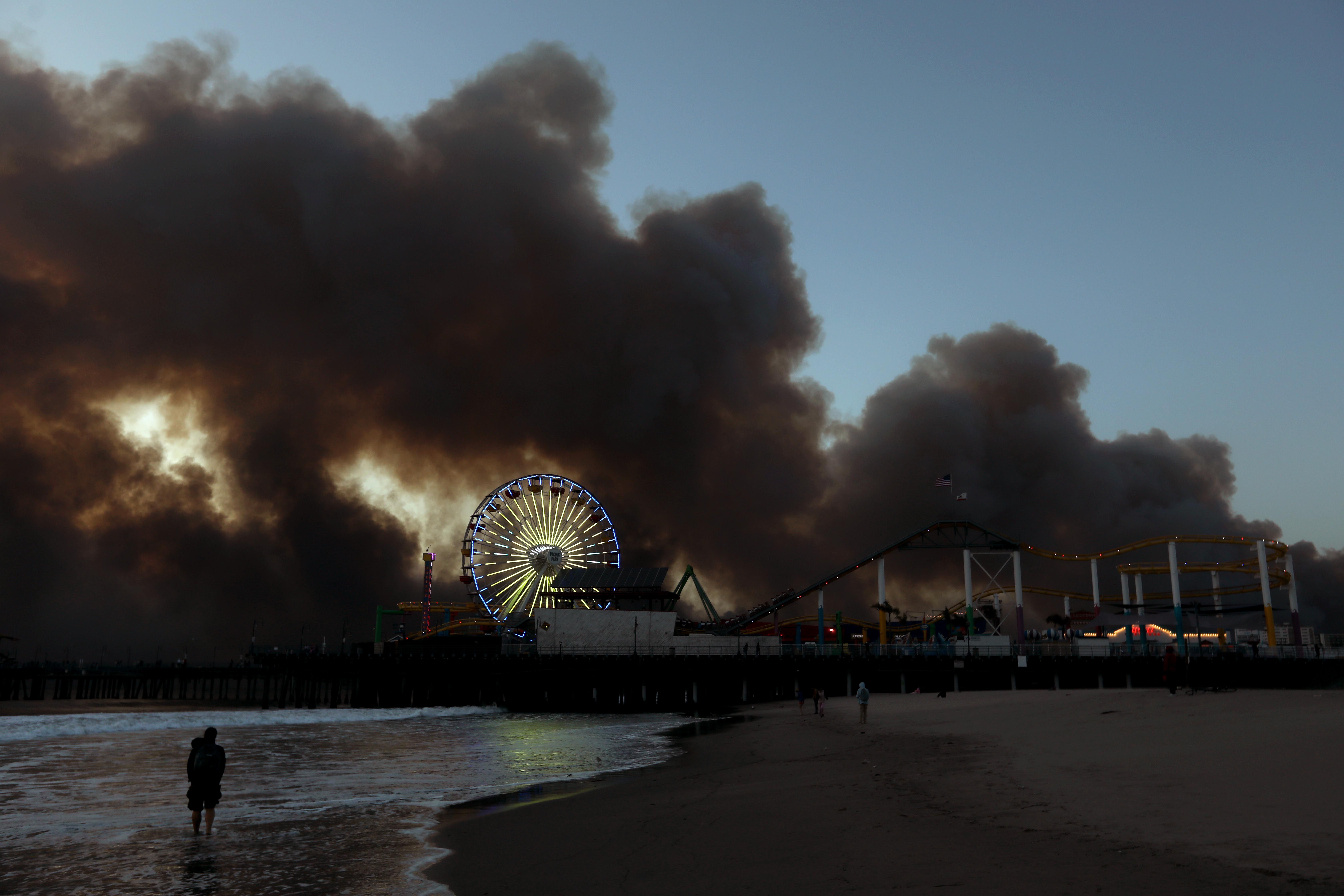 A person watching the fires in LA burn from the beach. 