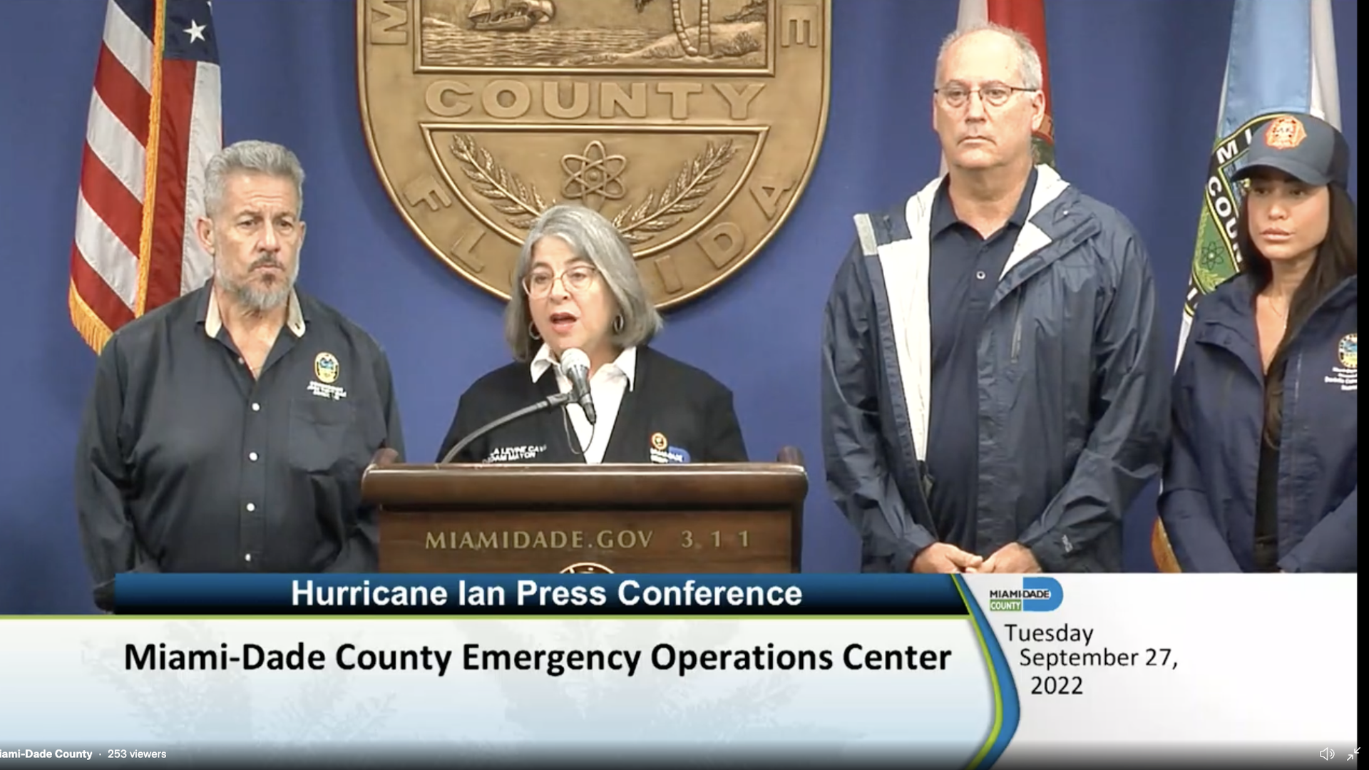 Miami-Dade County officials stand at a lectern for a press conference.