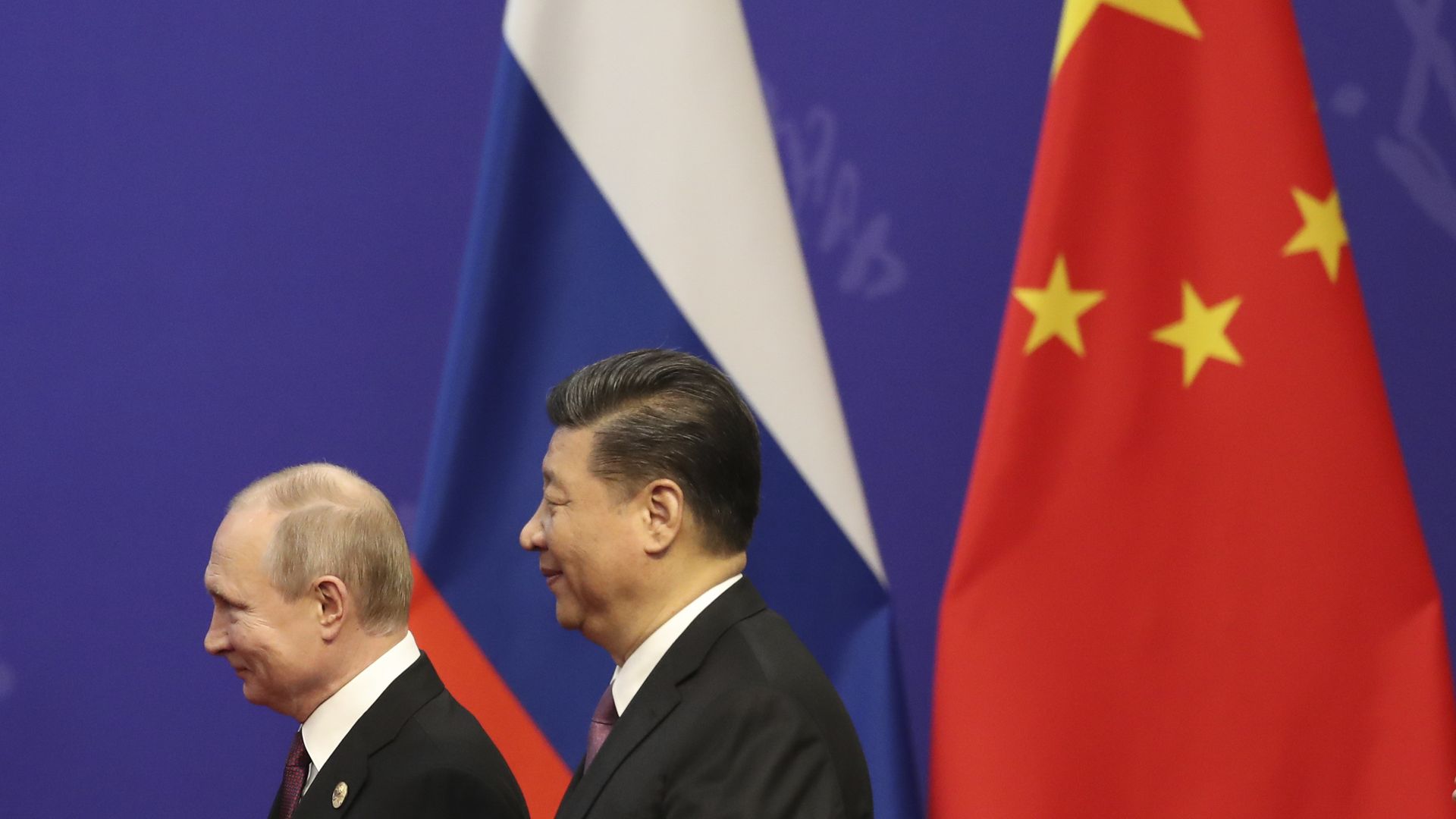 Russian President Vladimir Putin, left, and Chinese President Xi Jinping, right, in front of two flags