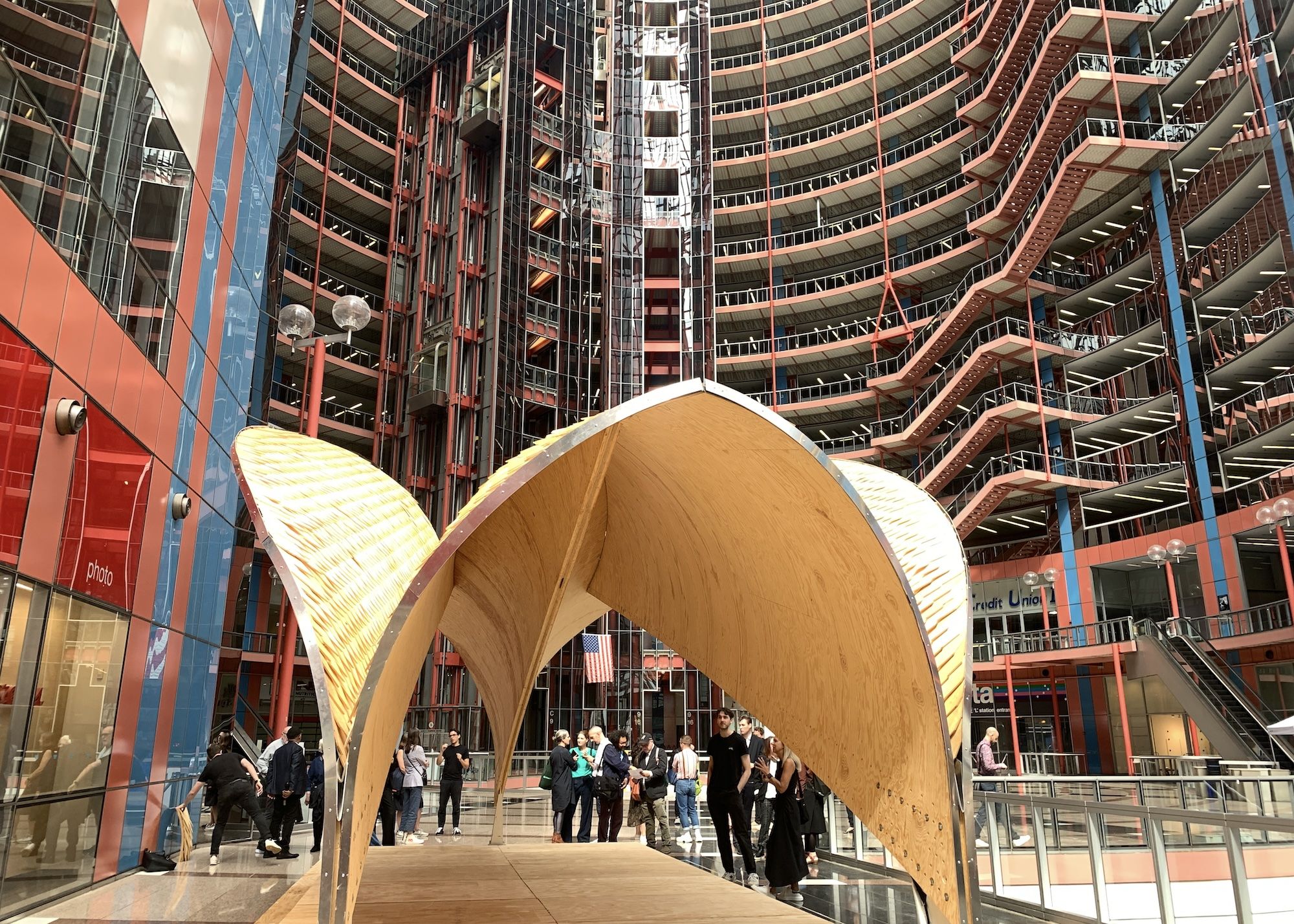 Plywood domed structure in front of red and blue paneling.