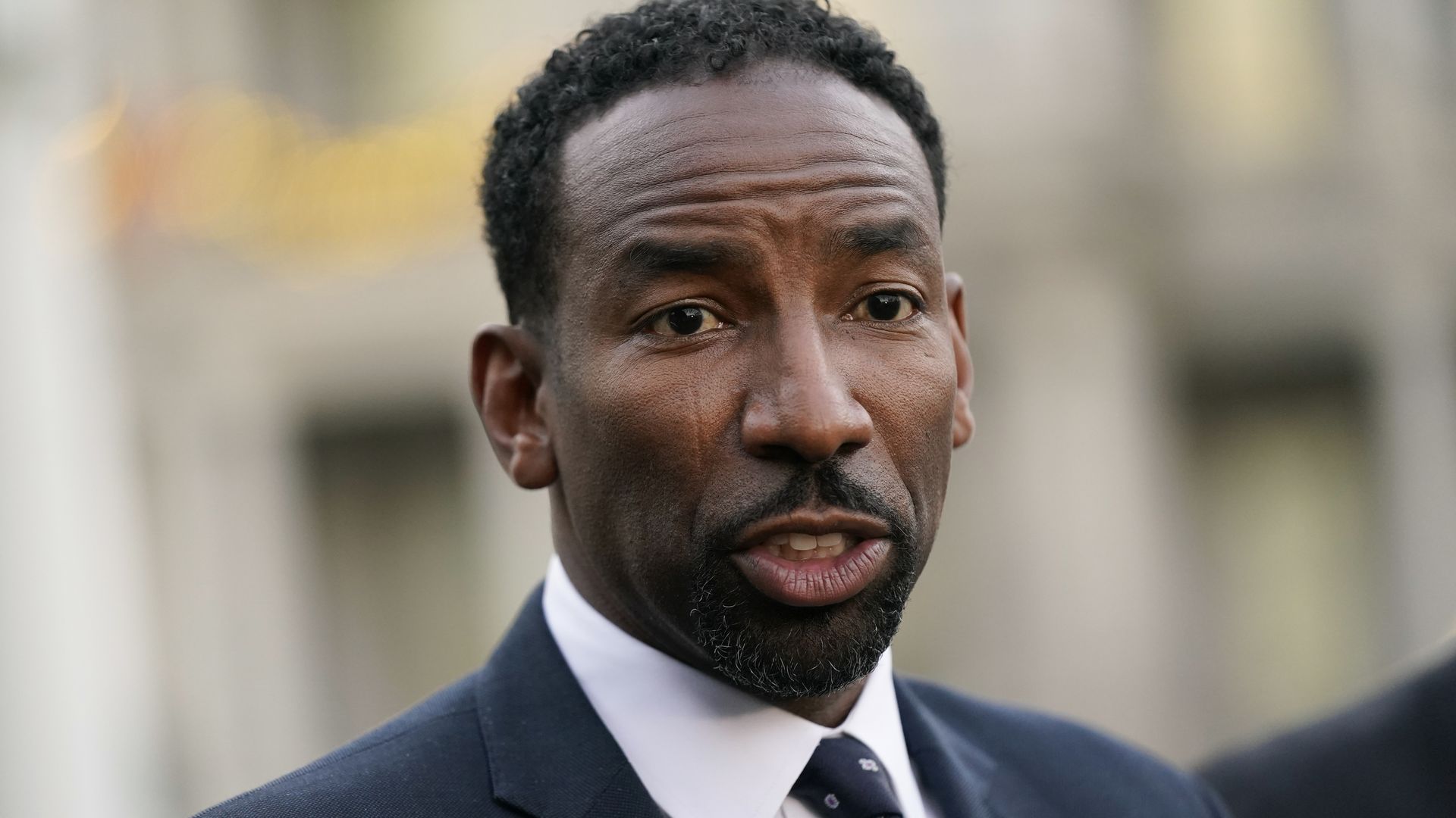 Andre Dickens, wearing a suit, addresses the media