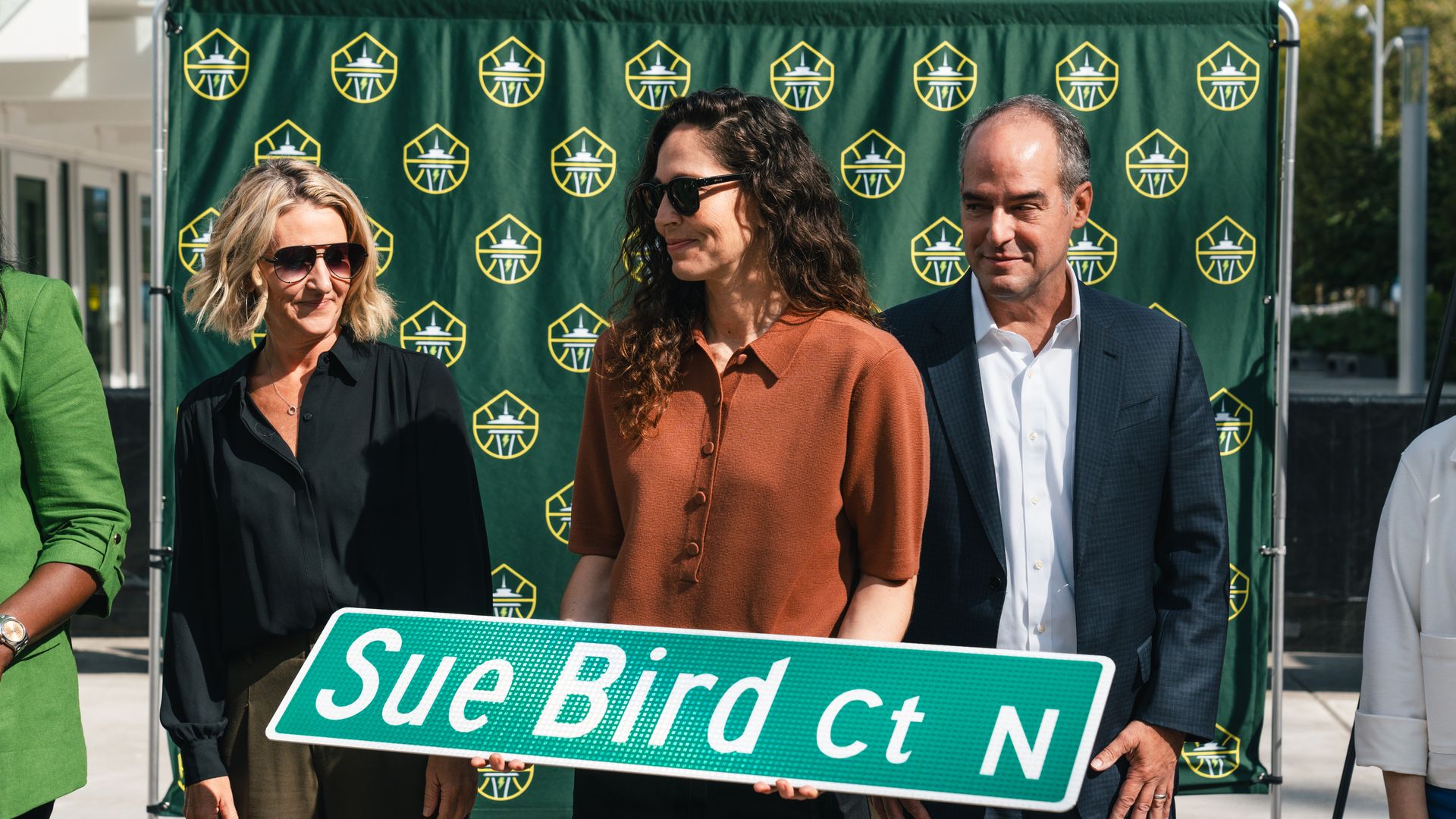 Seattle Storm's Sue Bird holds a street sign named for her. 