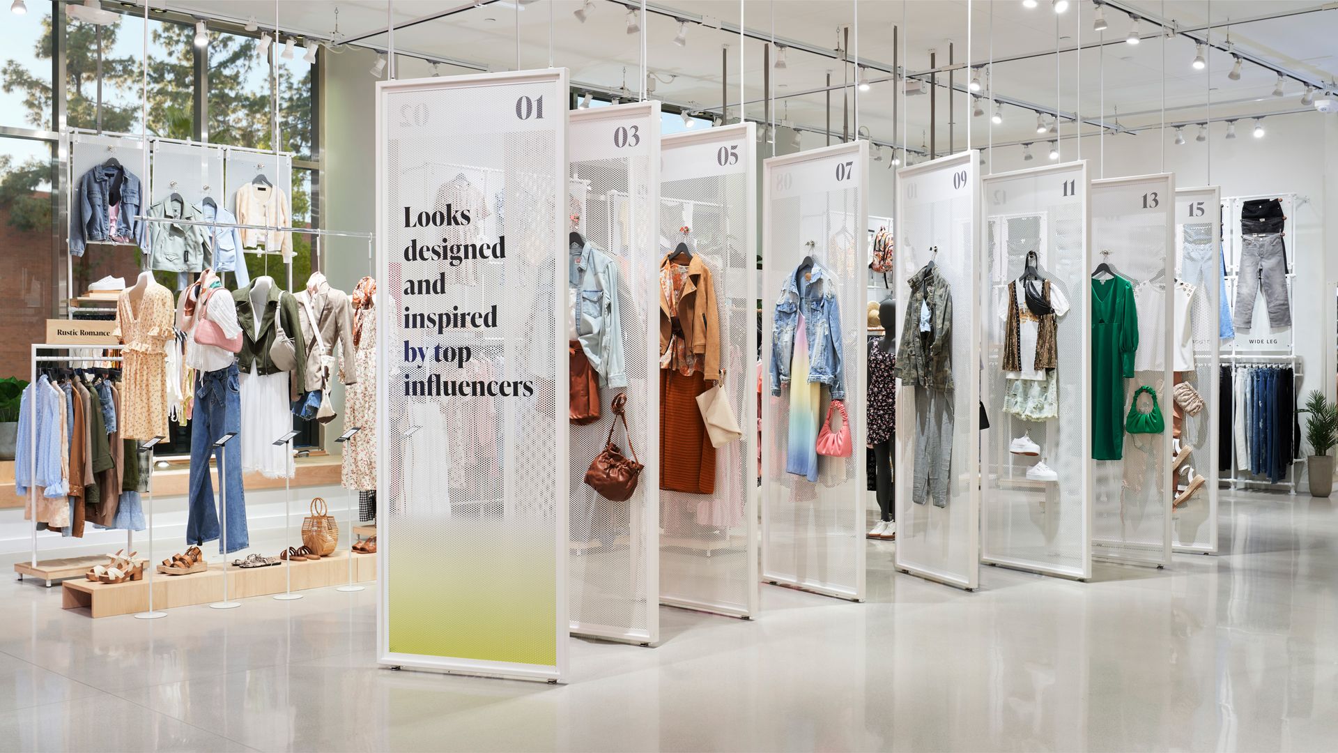 A row of outfits displayed on boards with a sign that says "Looks designed and inspired by top influencers"