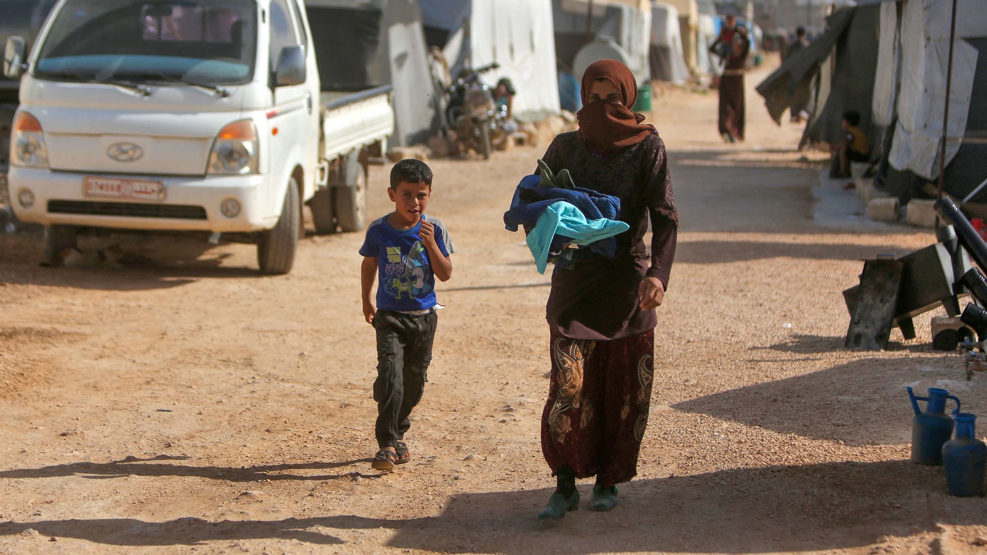 Displaced Syrians walk in a camp in northwestern Idlib province on April 30.