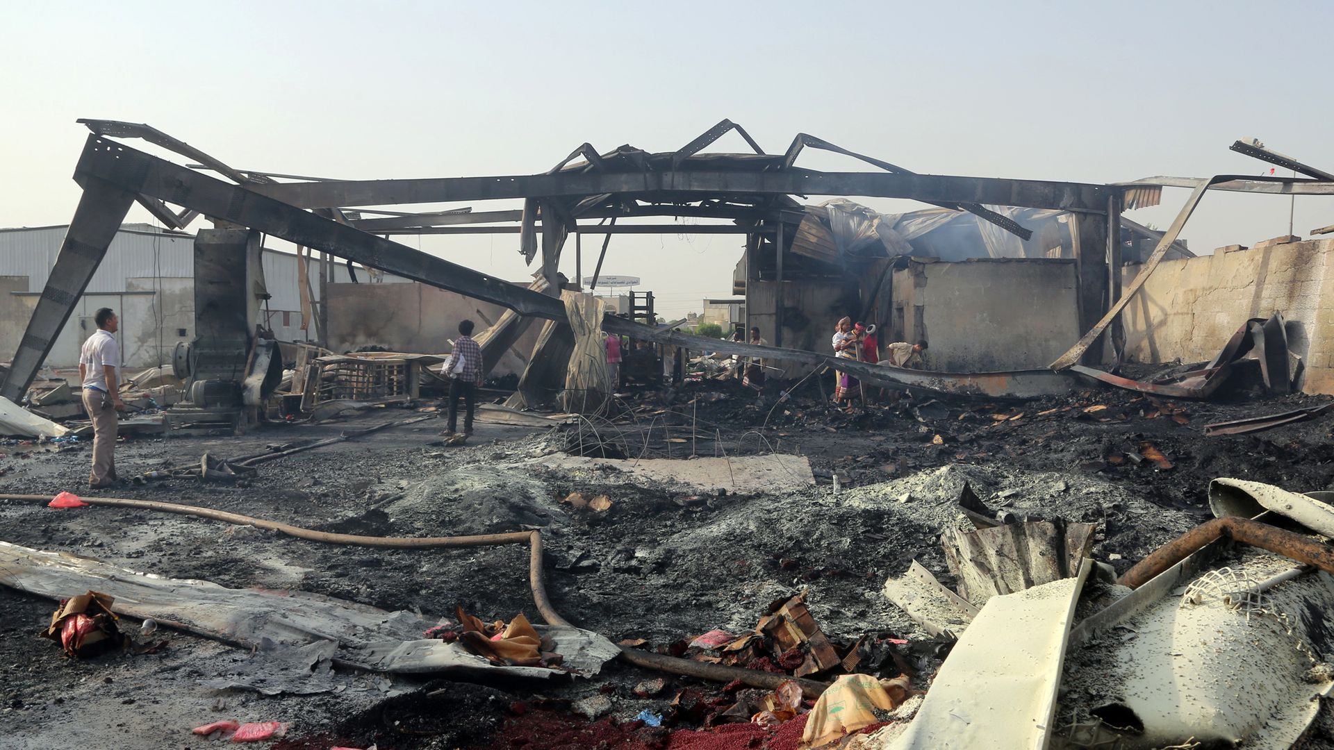 Men inspect a destroyed structure in Yemen.