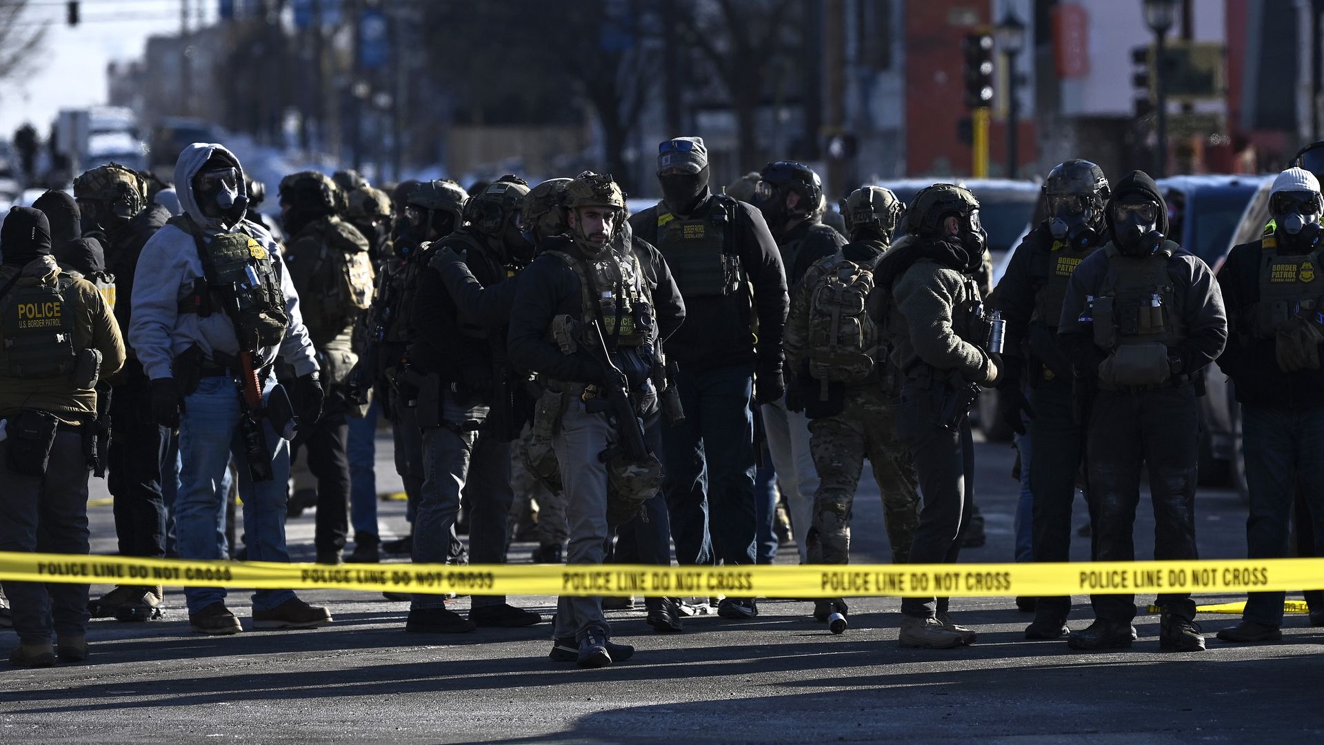 Agents armed behind a police tape