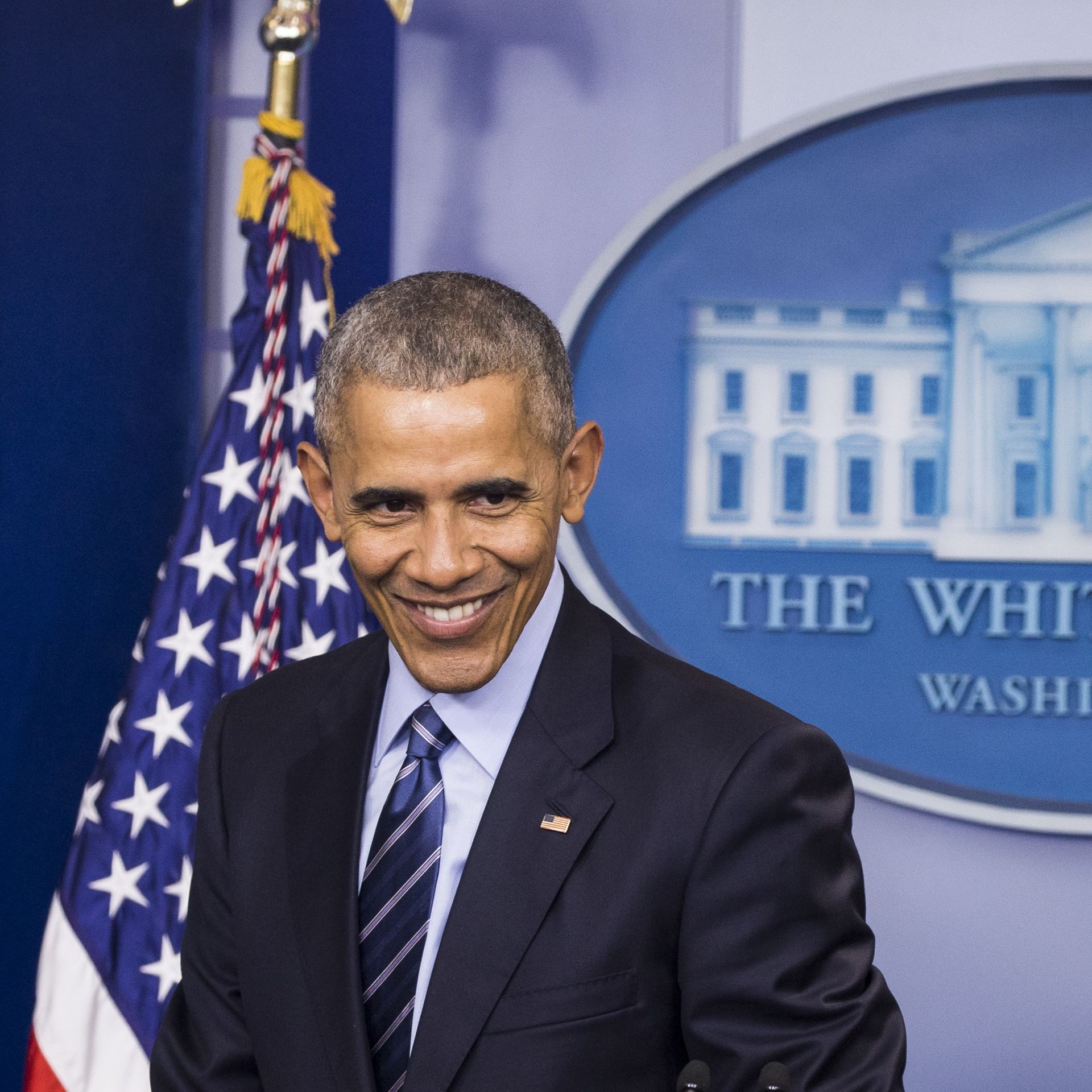 Then-President Obama, smiling, in the White House briefing room.