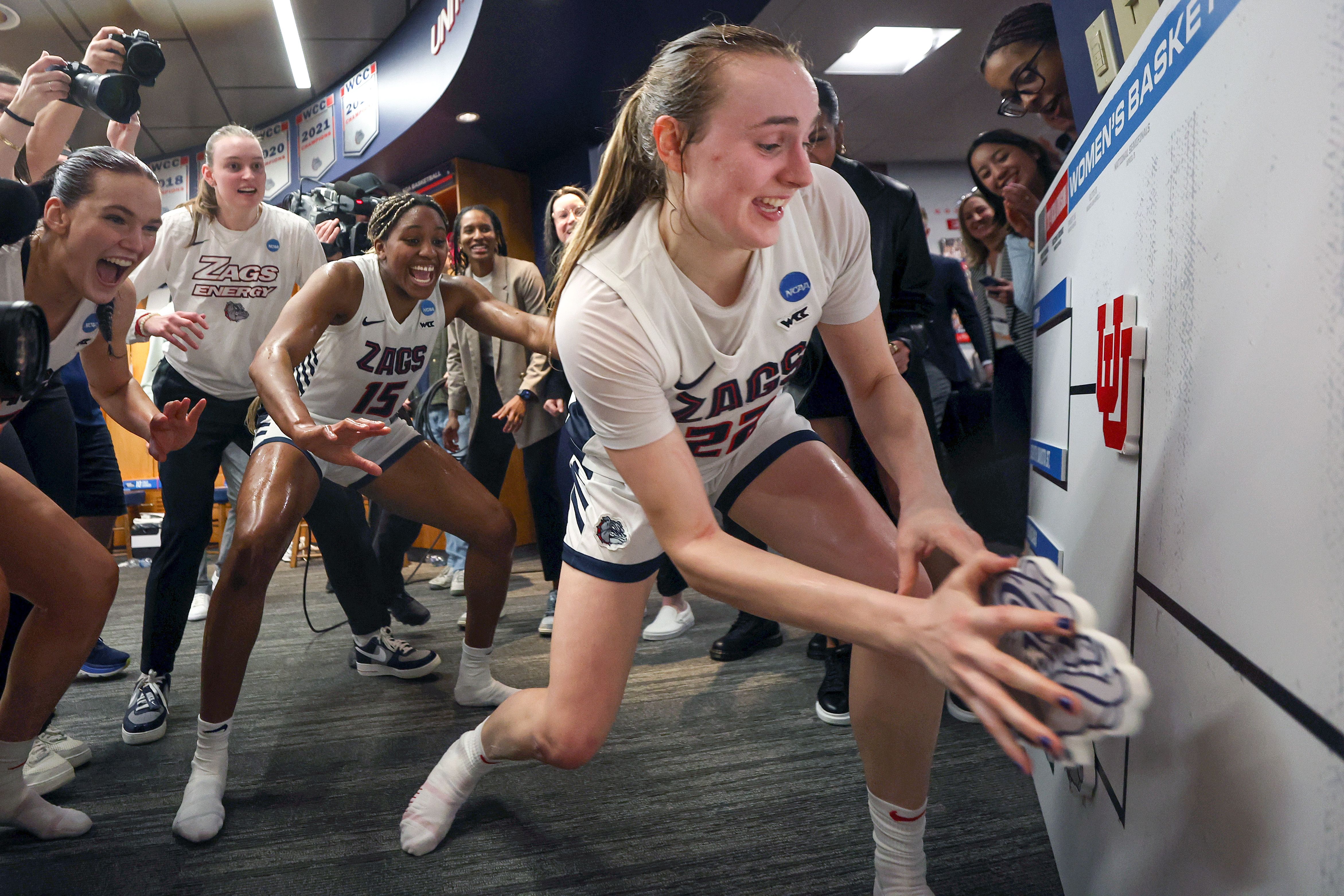 A Gonzaga player moves the team's logo on a bracket.