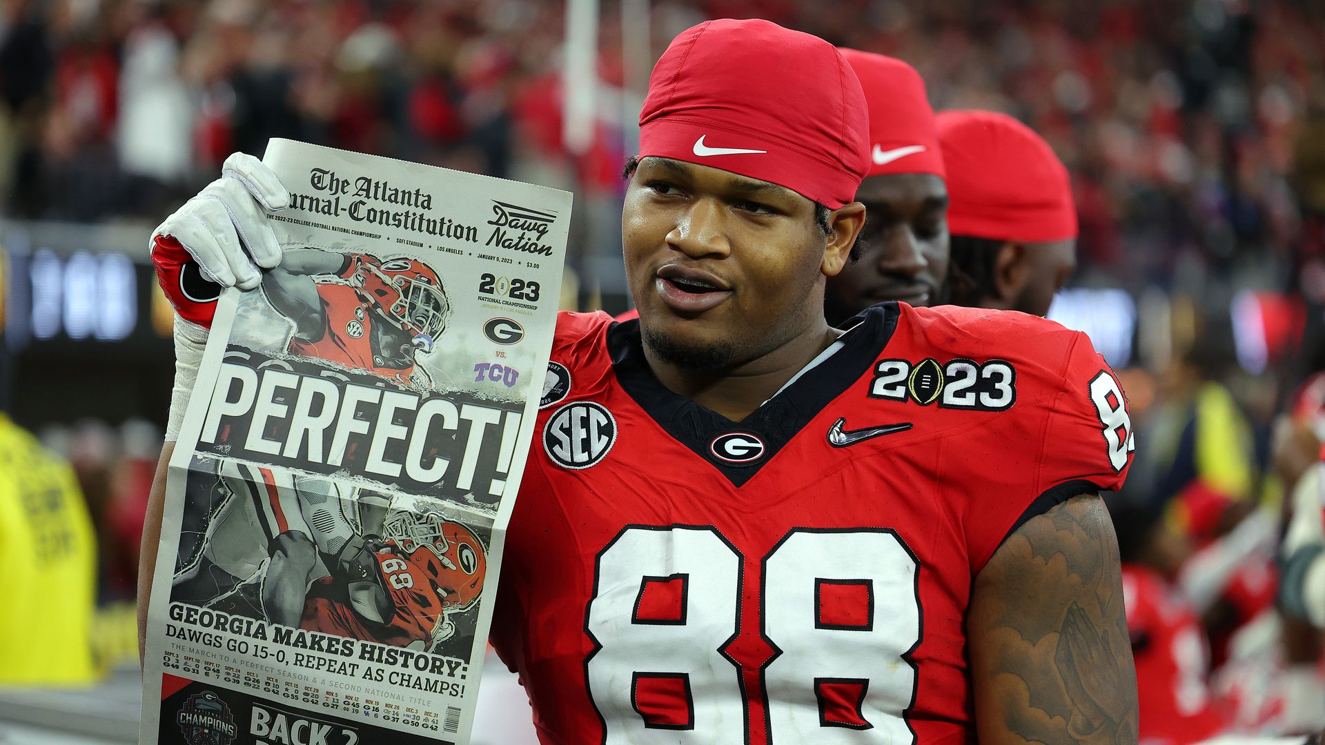 Former Georgia defensive tackle Jalen Carter holds up a newspaper celebrating the team's national championship