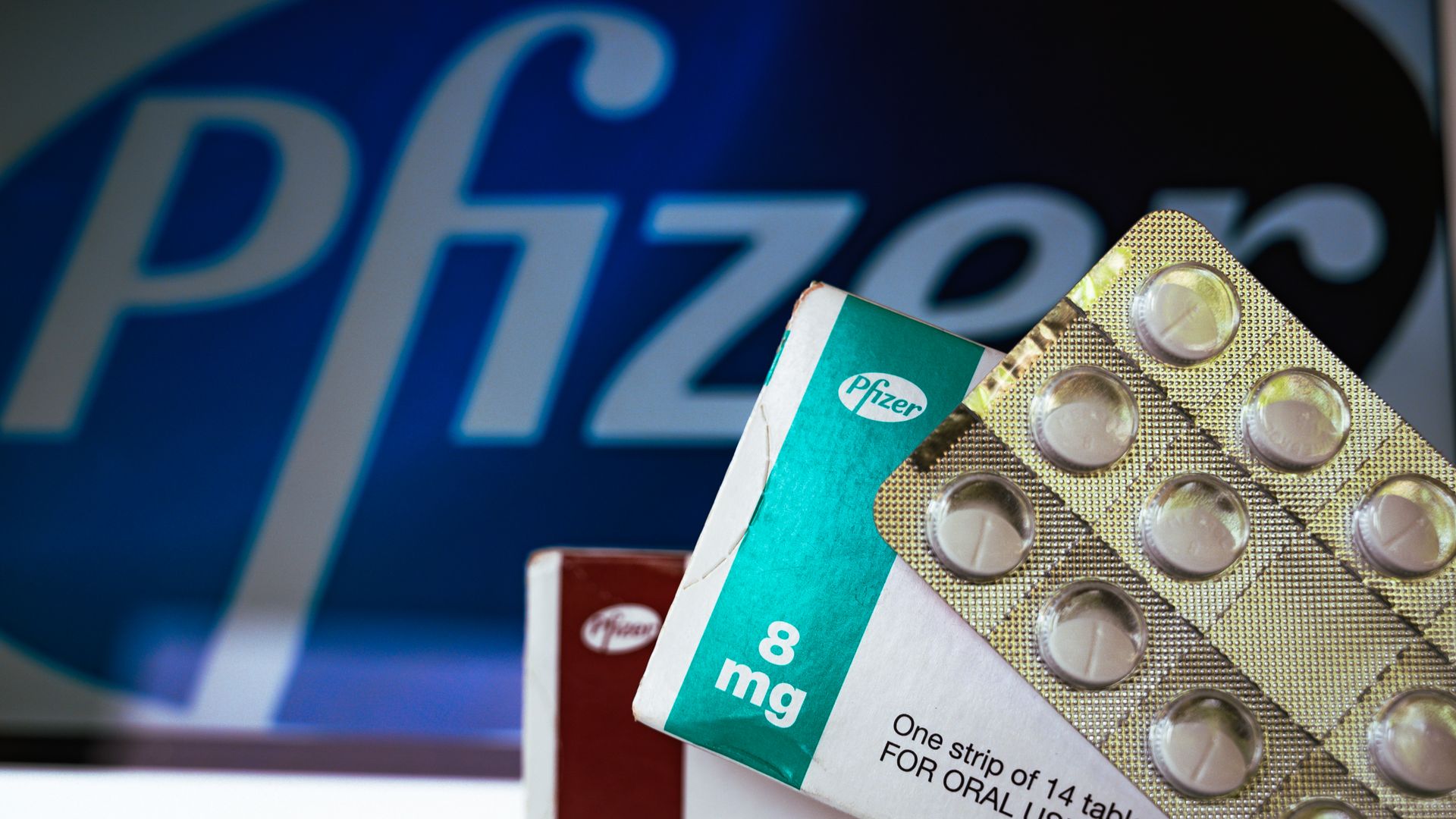 Medicine pills are seen with Pfizer logo.