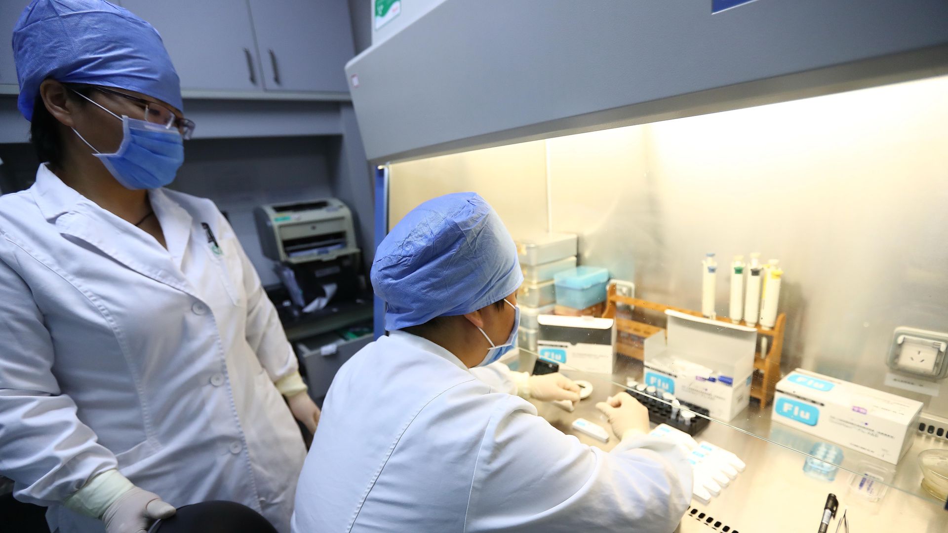 Two lab scientists testing for influenza at a Chinese research facility